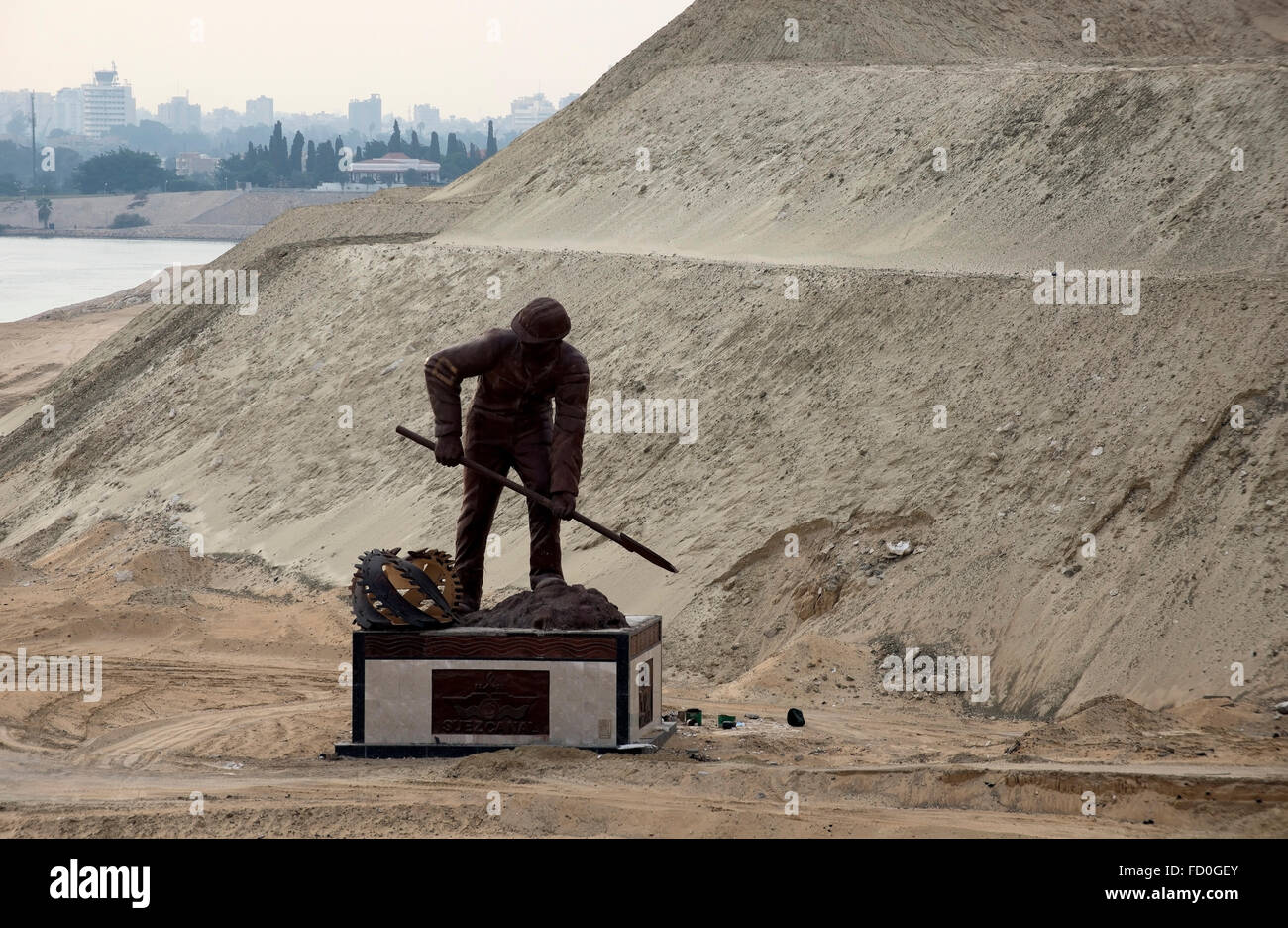 Statue of an Egyptian labourer at work digging in the sand in the Suez Canal, North Africa. Stock Photo