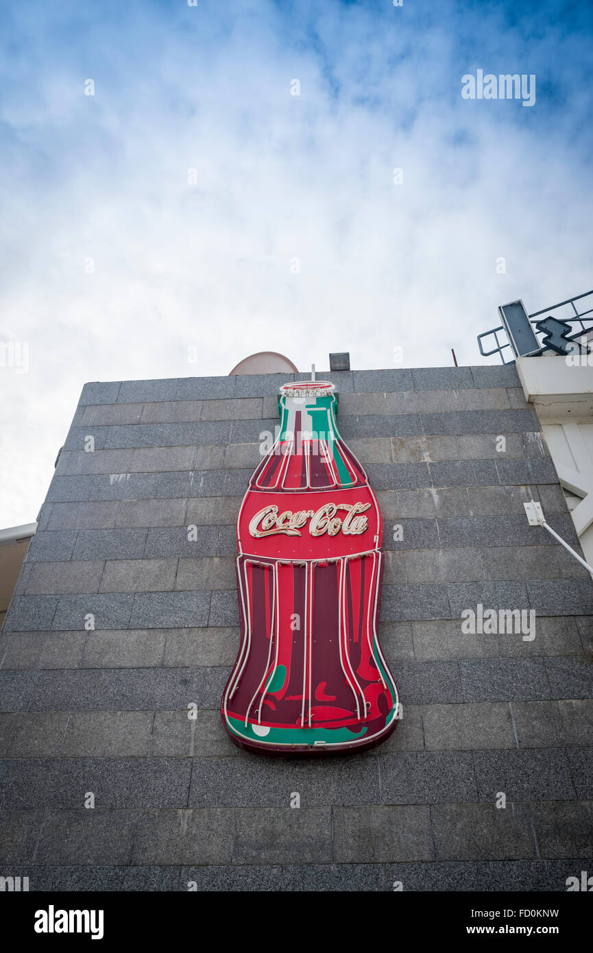 Large neon Coca Cola bottle sign on the side of a building. Stock Photo