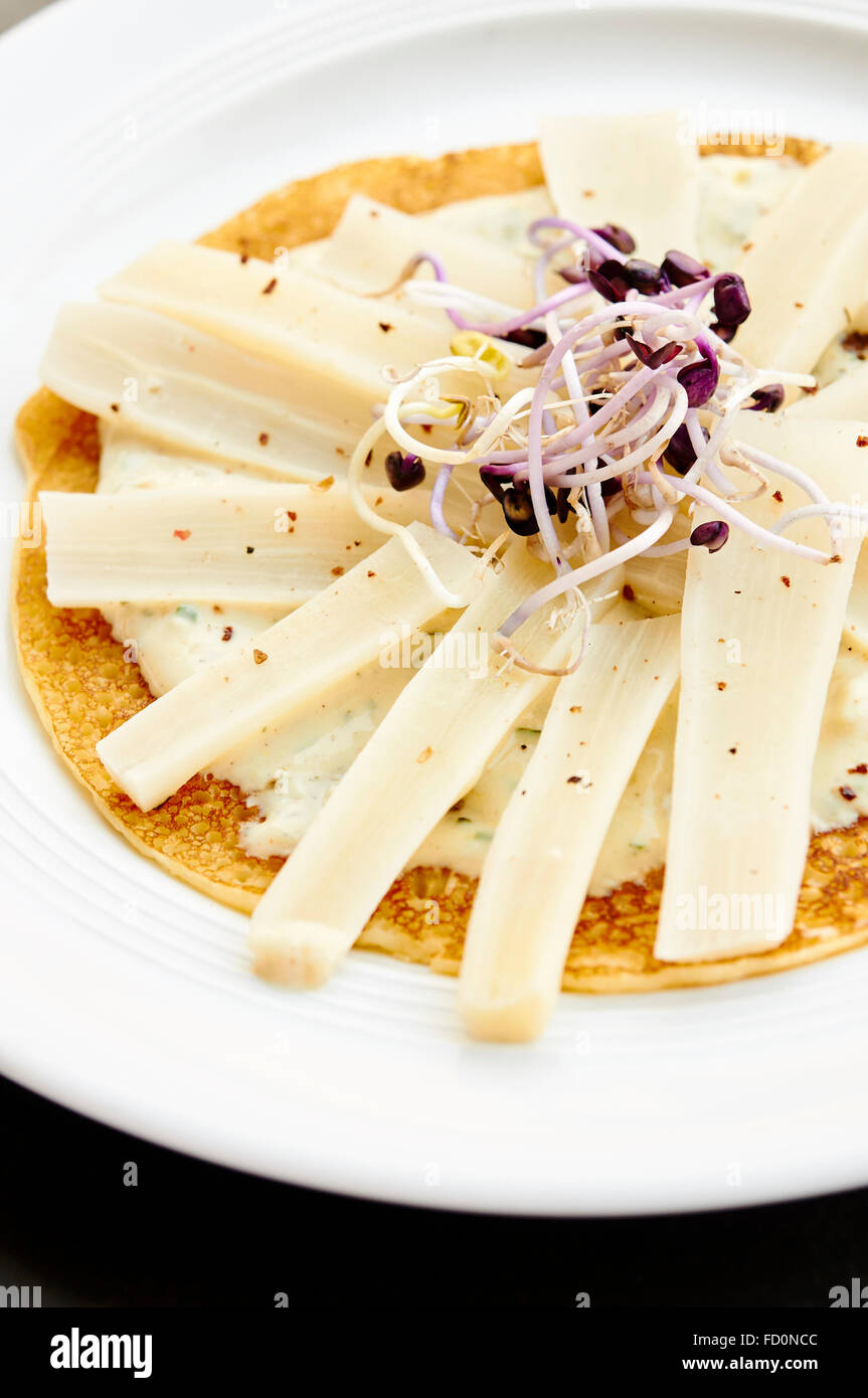 Plate with black salsify with radish sprouts on a crepe. Stock Photo