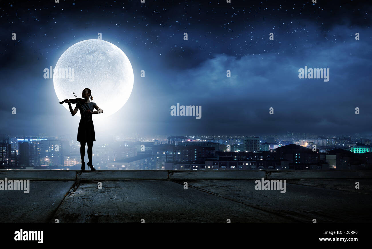 Silhouette of woman playing violin at night Stock Photo - Alamy