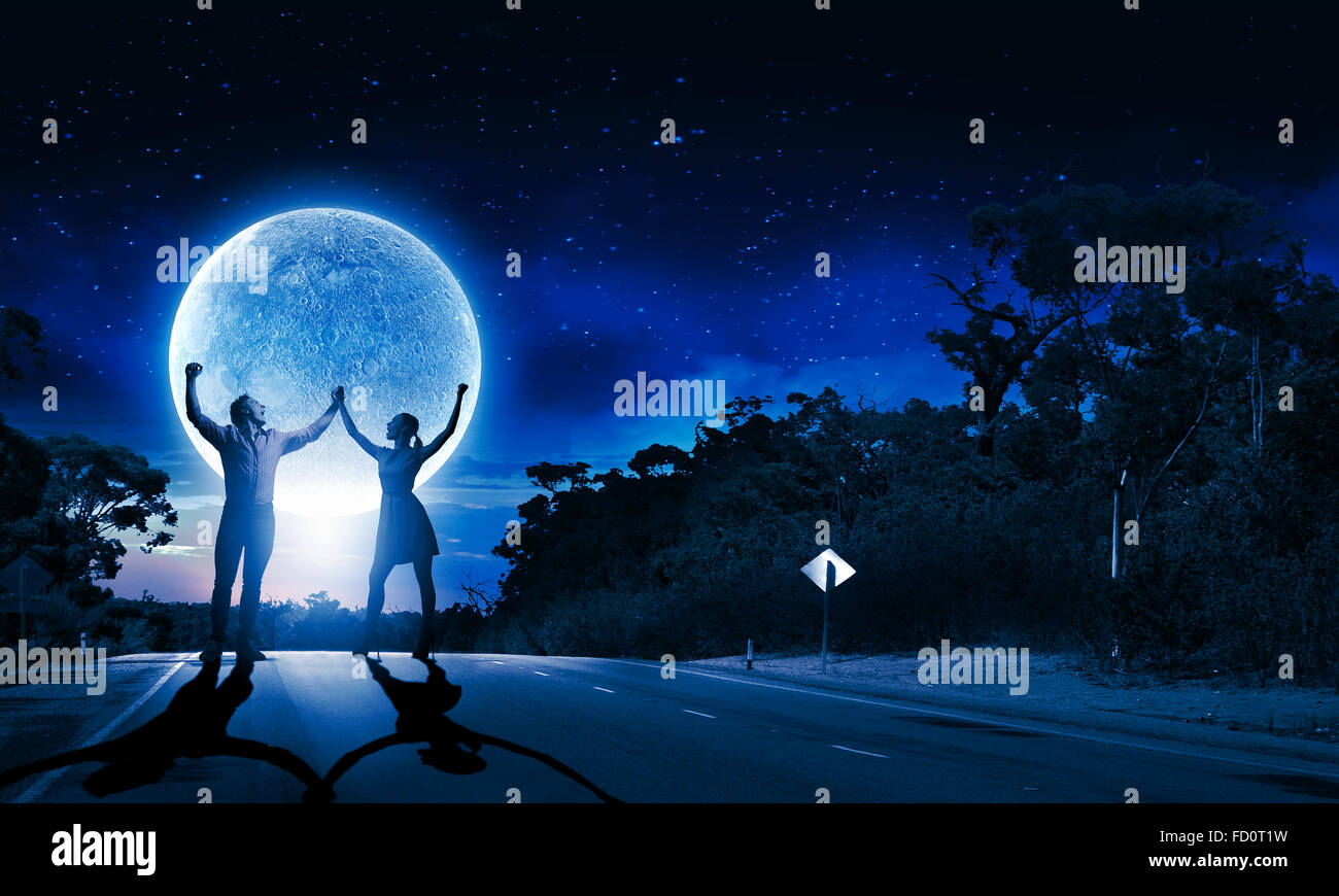 Silhouettes of young couple against full moon Stock Photo - Alamy