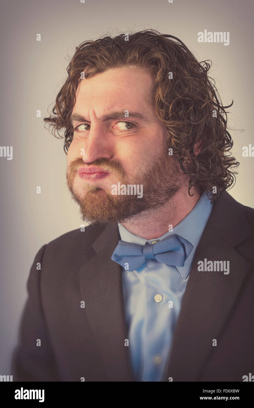 Bearded man holds his breath in anticipation and is turning blue Stock