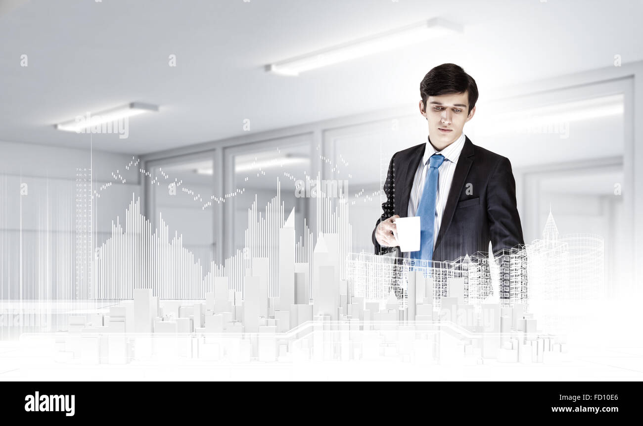 Young businessman examining model of construction project Stock Photo ...