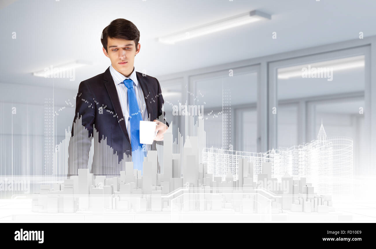 Young businessman examining model of construction project Stock Photo ...