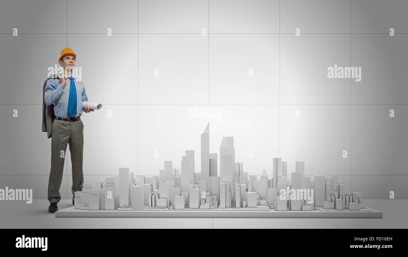 Young businessman examining model of construction project Stock Photo ...