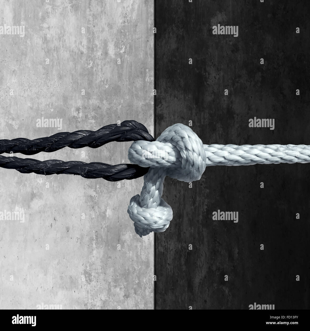 Racial unity concept as a symbol against racism in society as a white and black rope tied together as a metaphor for friendship Stock Photo