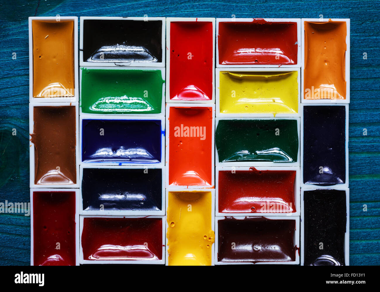 Watercolor paints on a wooden blue surface. Stock Photo