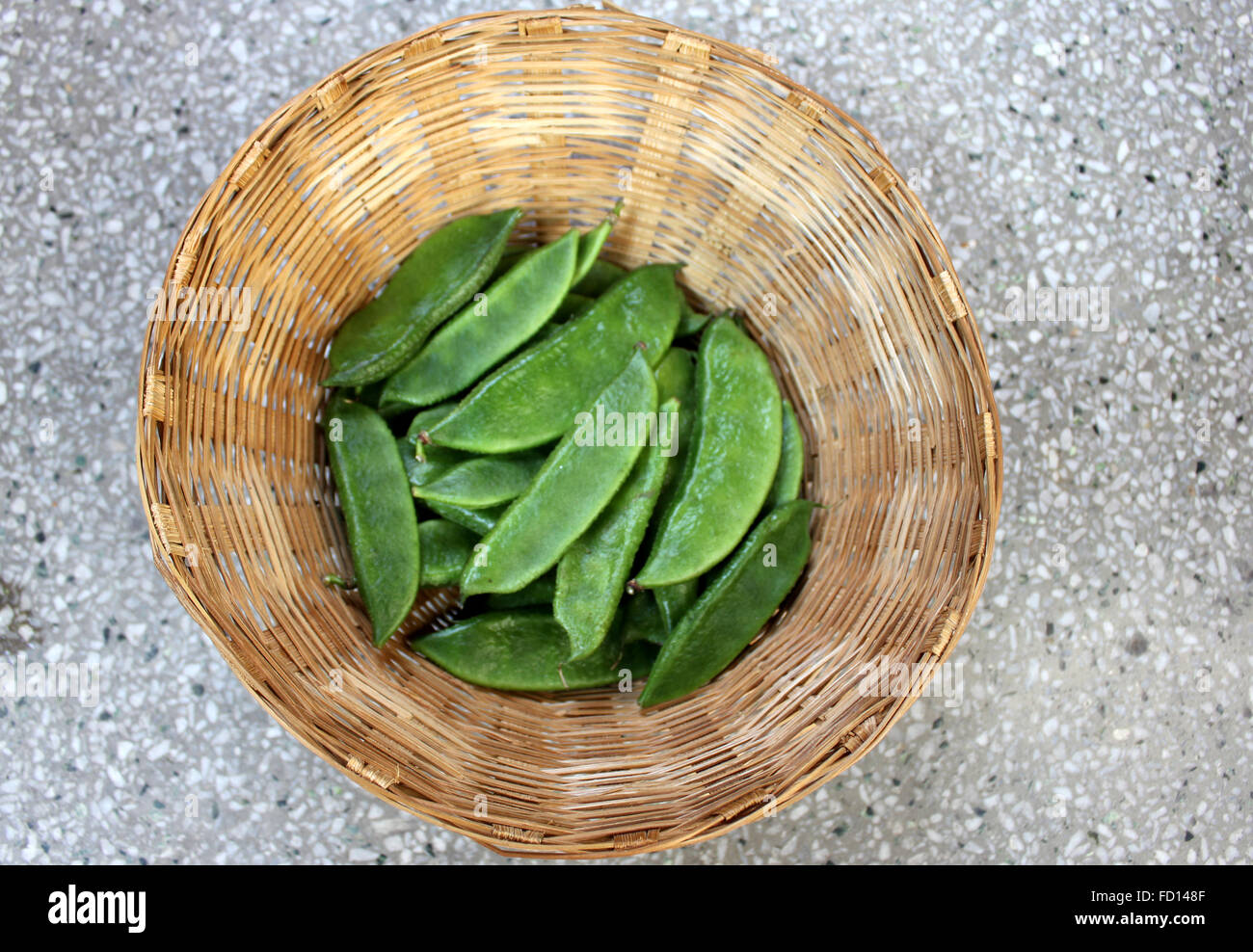 Dolichos lablab, vegetable vine crop with white flowers, unopened pods in a basket, used as vegetable, ripe seeds as pulse Stock Photo