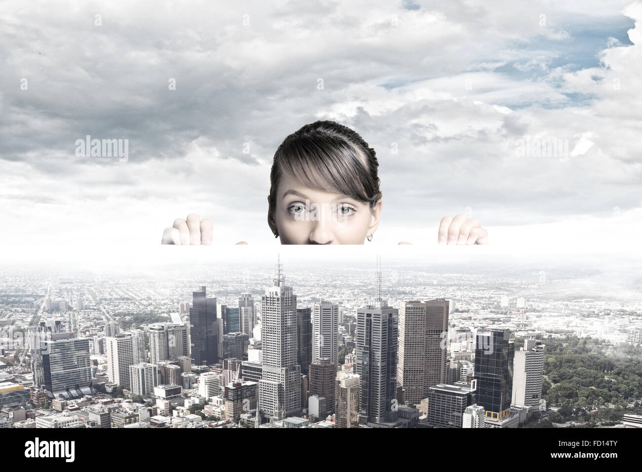 Half of face of businesswoman looking from under table at city model ...
