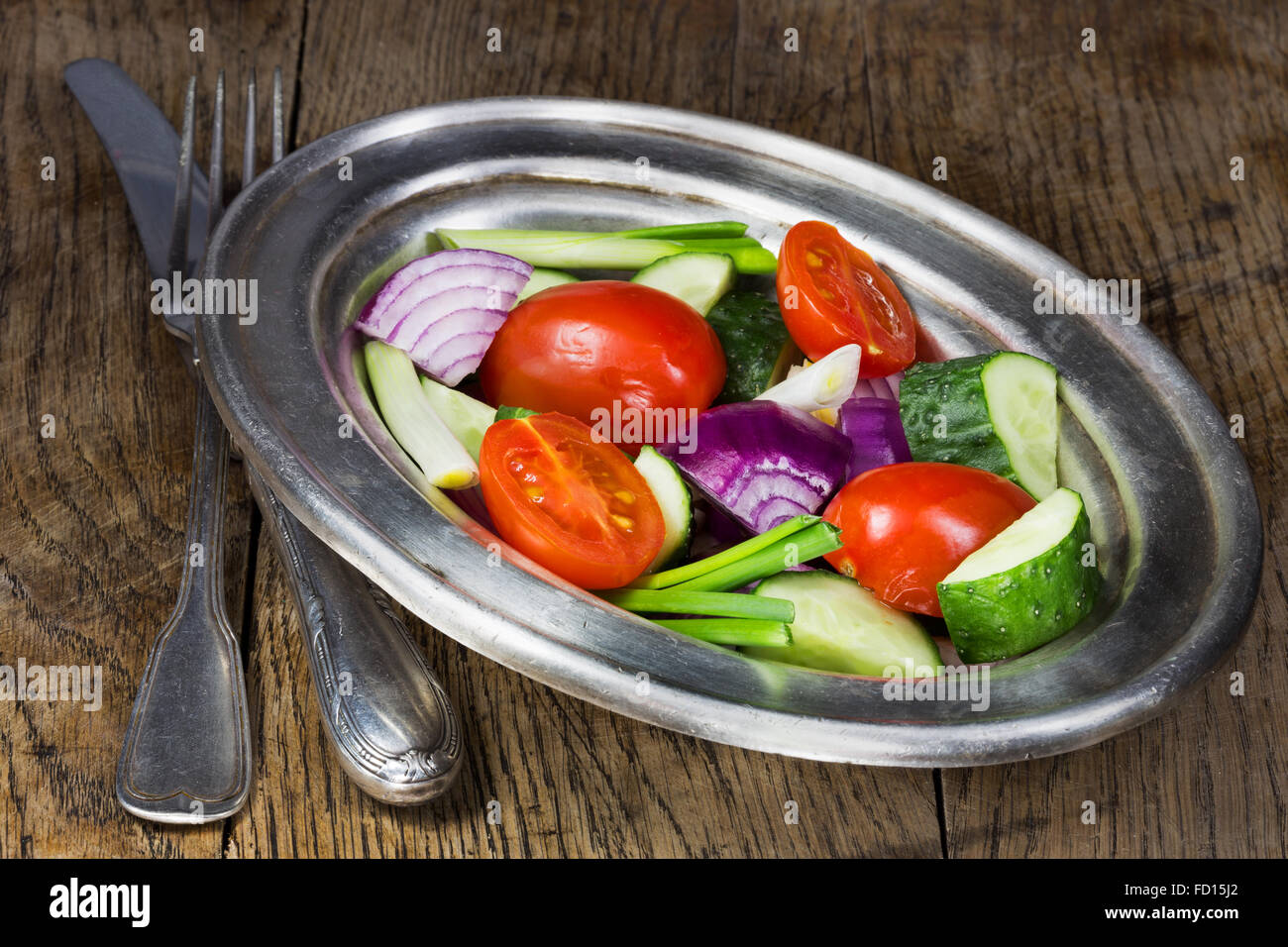 Fresh vegetables in a silver flatware on old wooden table. Selective focus Stock Photo