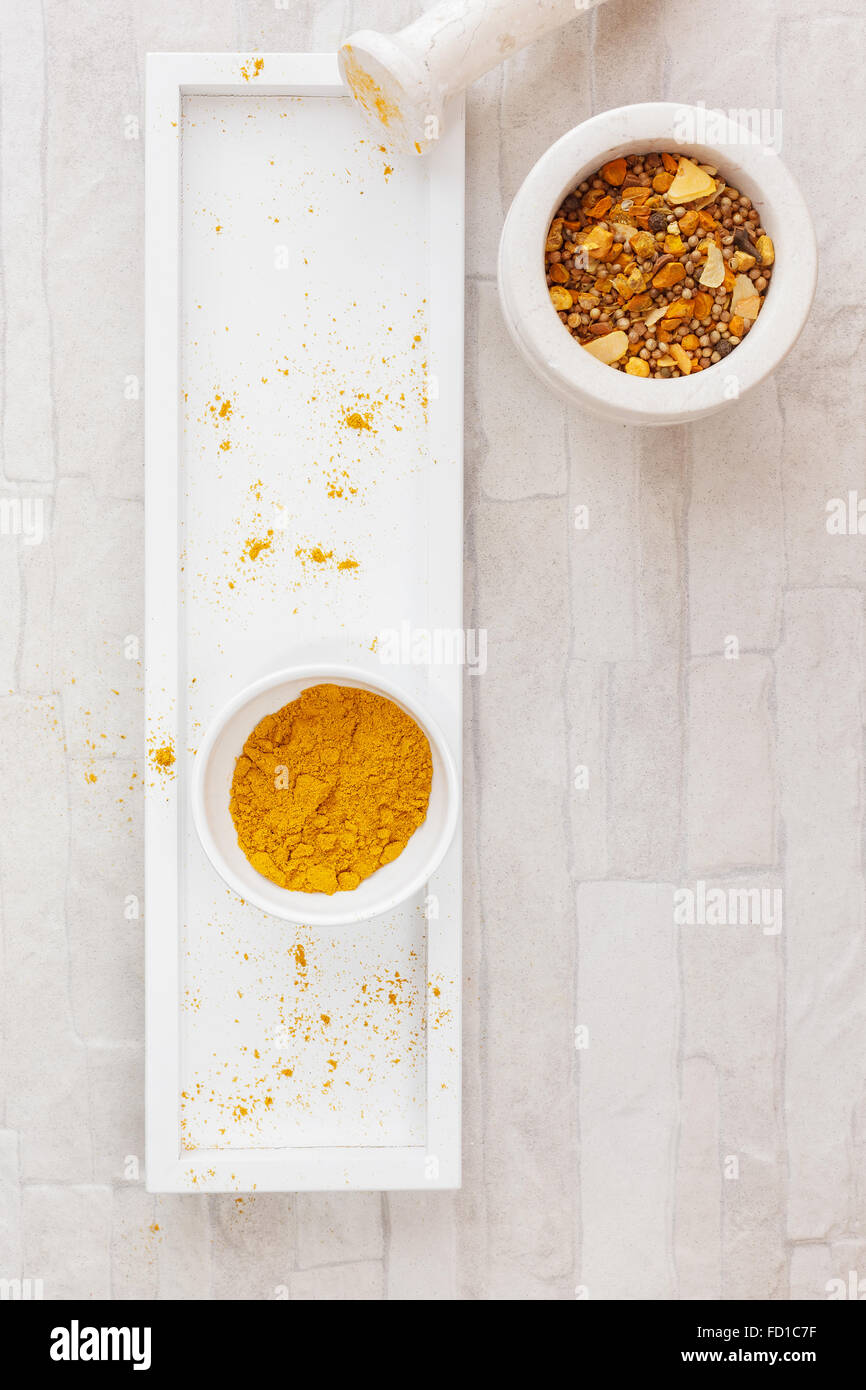 Curry powder on tray .Home-made curry powder being crushed in a mortar. Stock Photo
