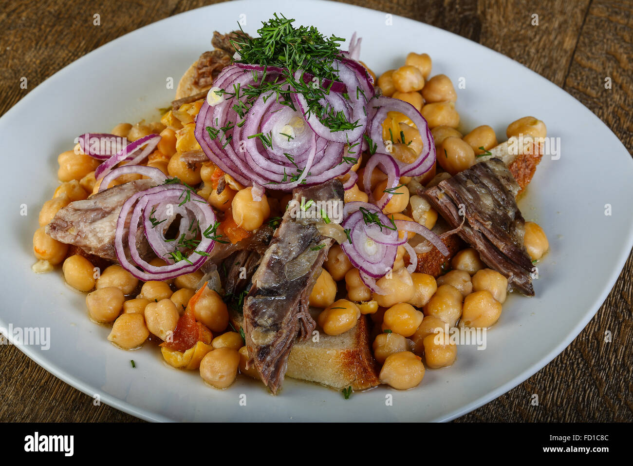 Beef with chickpea served onion rings and parsley Stock Photo Alamy