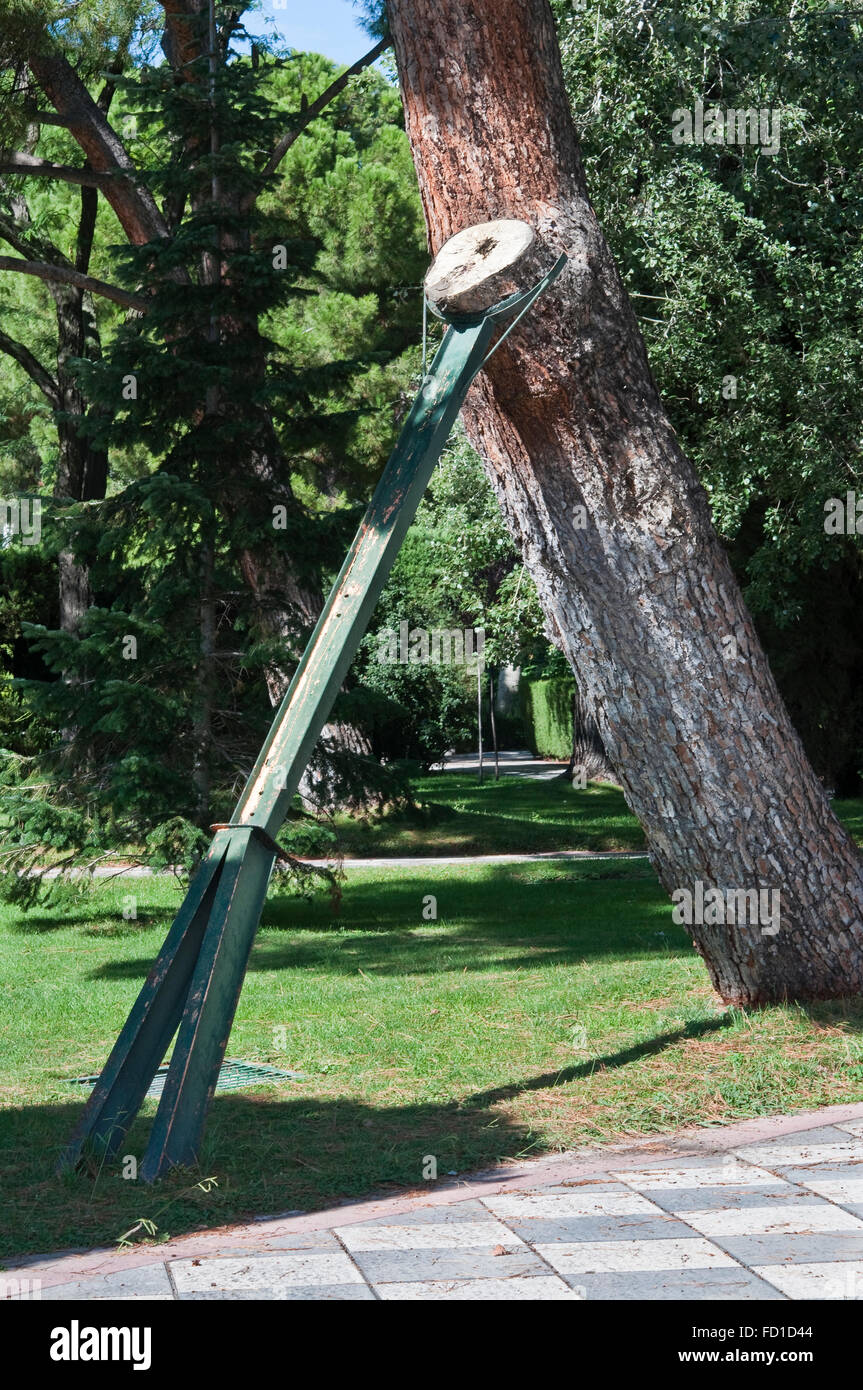 Metallic beam to prop up a tree in a public garden Stock Photo