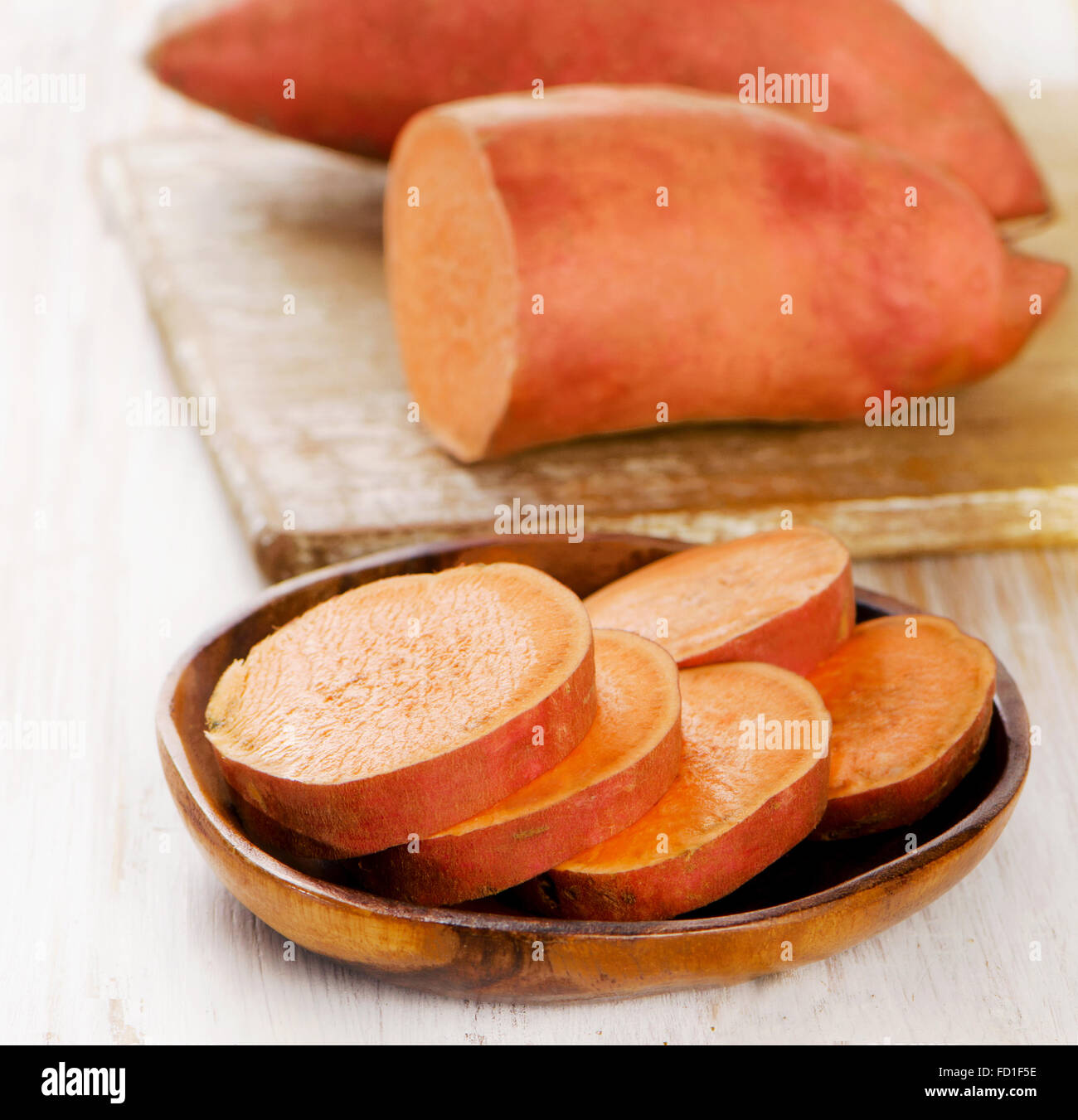 Raw sweet potatoes on wooden table . Selective focus Stock Photo
