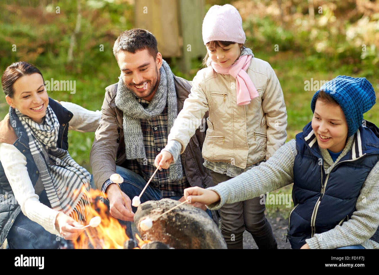 happy family roasting marshmallow over campfire Stock Photo - Alamy