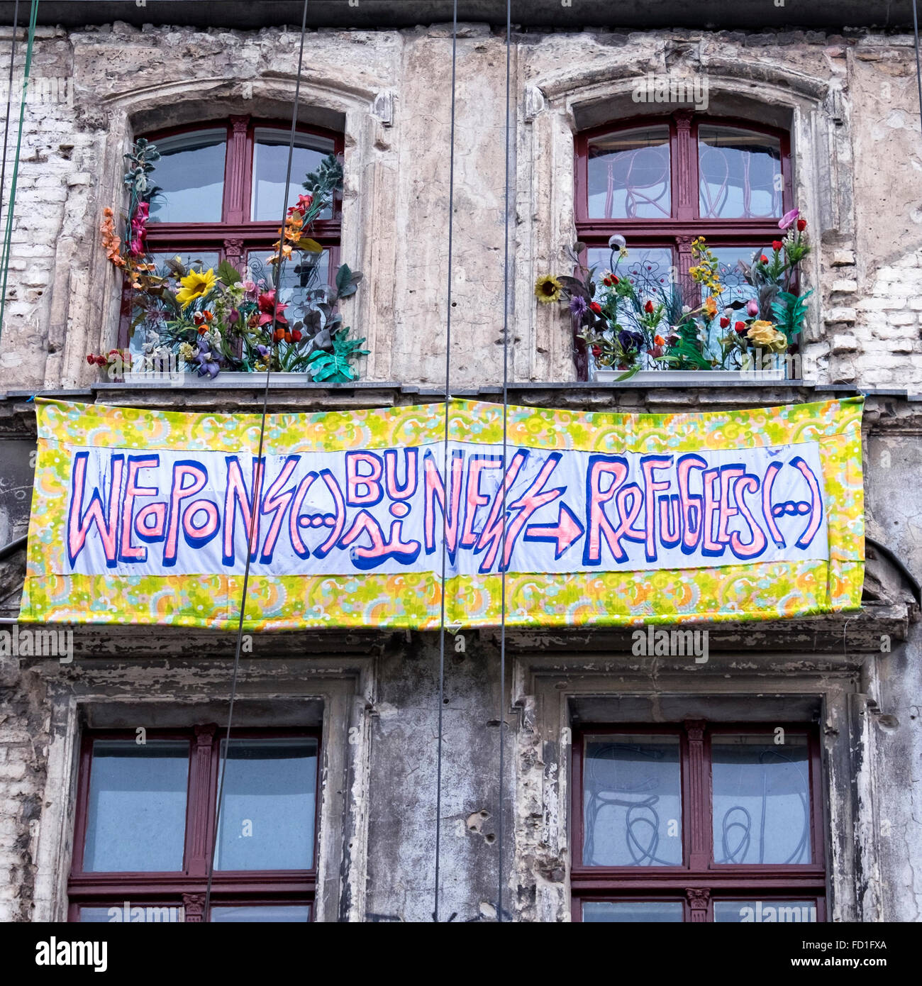 'Weapons Business refugees' banner on dilapidated, weathered old apartment building in Auguststrasse, Berlin<Germany Stock Photo