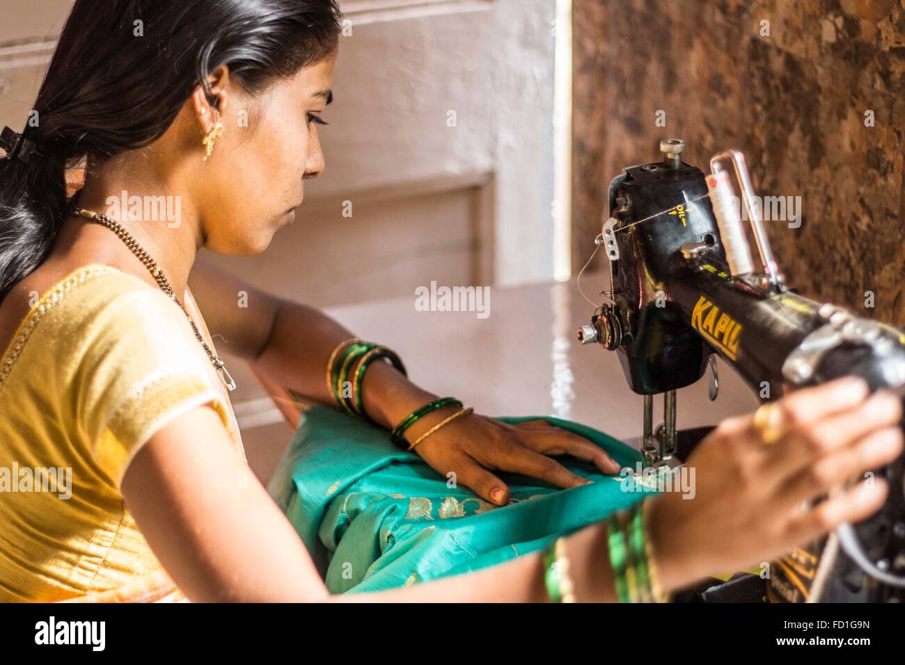 A woman sews in a stitching course in Mumbai, India Stock Photo