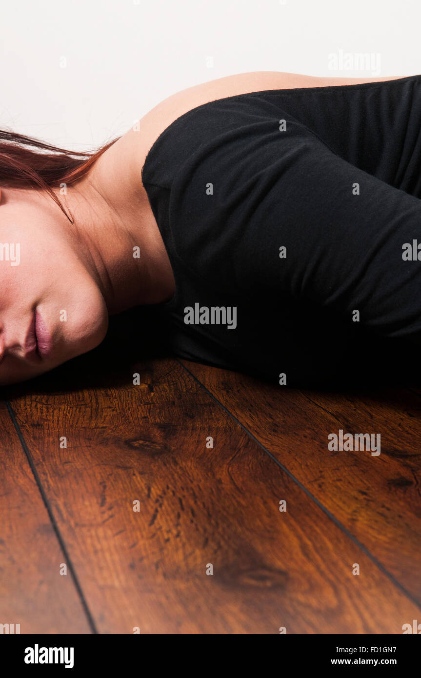 Woman lying down on the floor Stock Photo