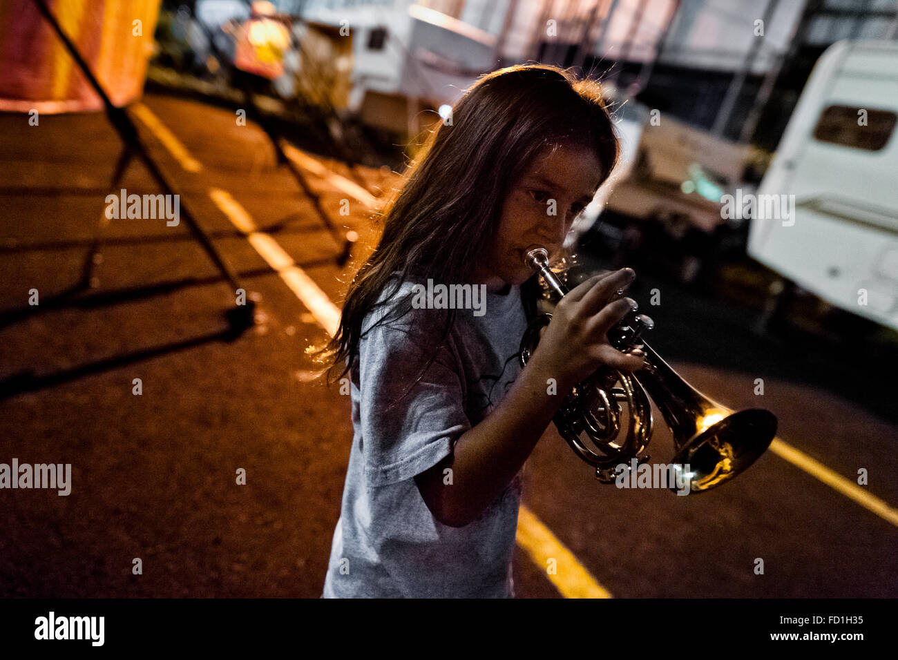 A young boy, a member of the old circus family Fuentes Gasca from Mexico, plays trumpet in the backstage of Circus Renato, in San Salvador, El Salvador. Stock Photo