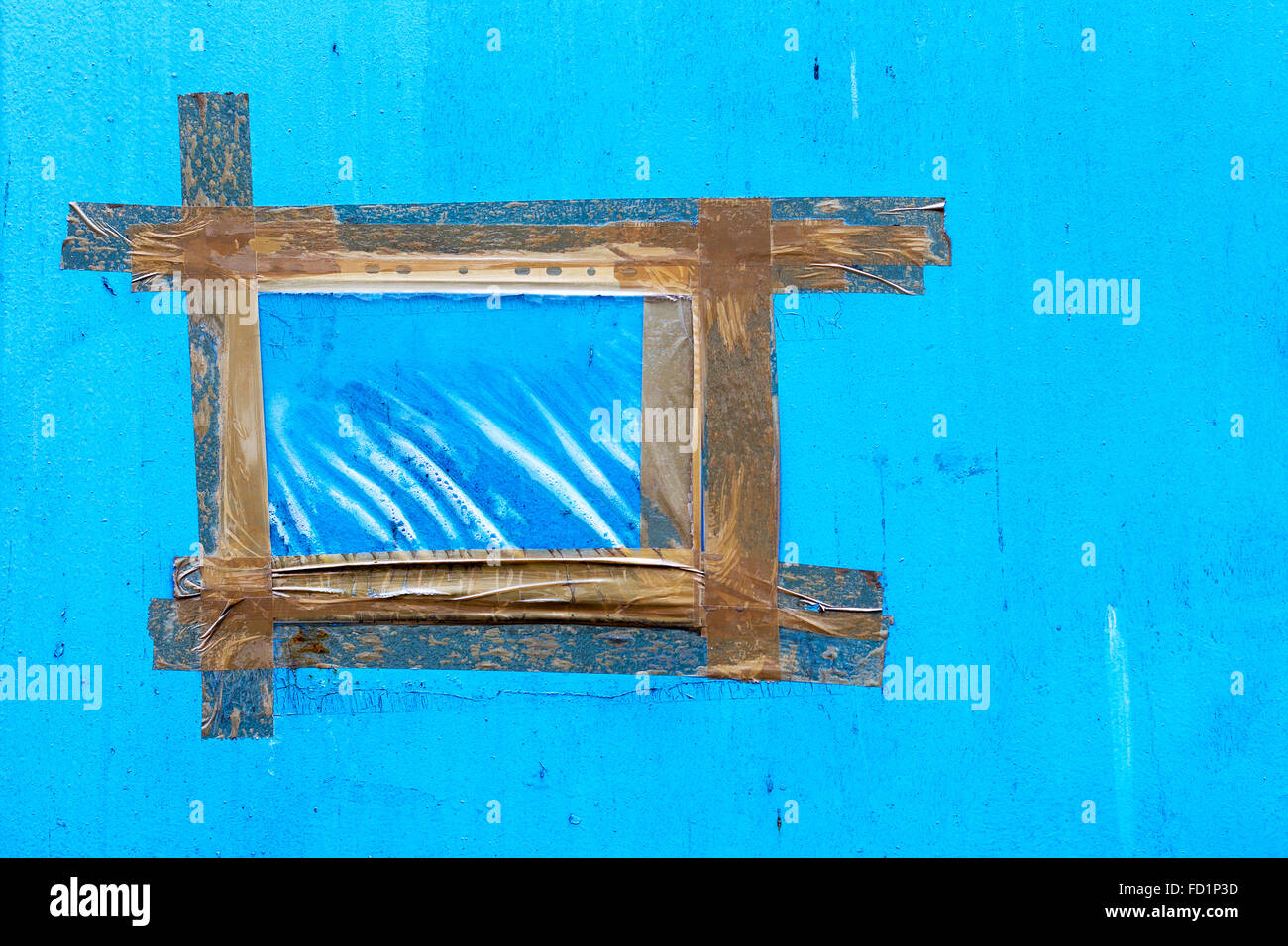 Vintage blue wall with cracks, scratches, frame is made from strips of old adhesive tape. Textured background for your concept o Stock Photo