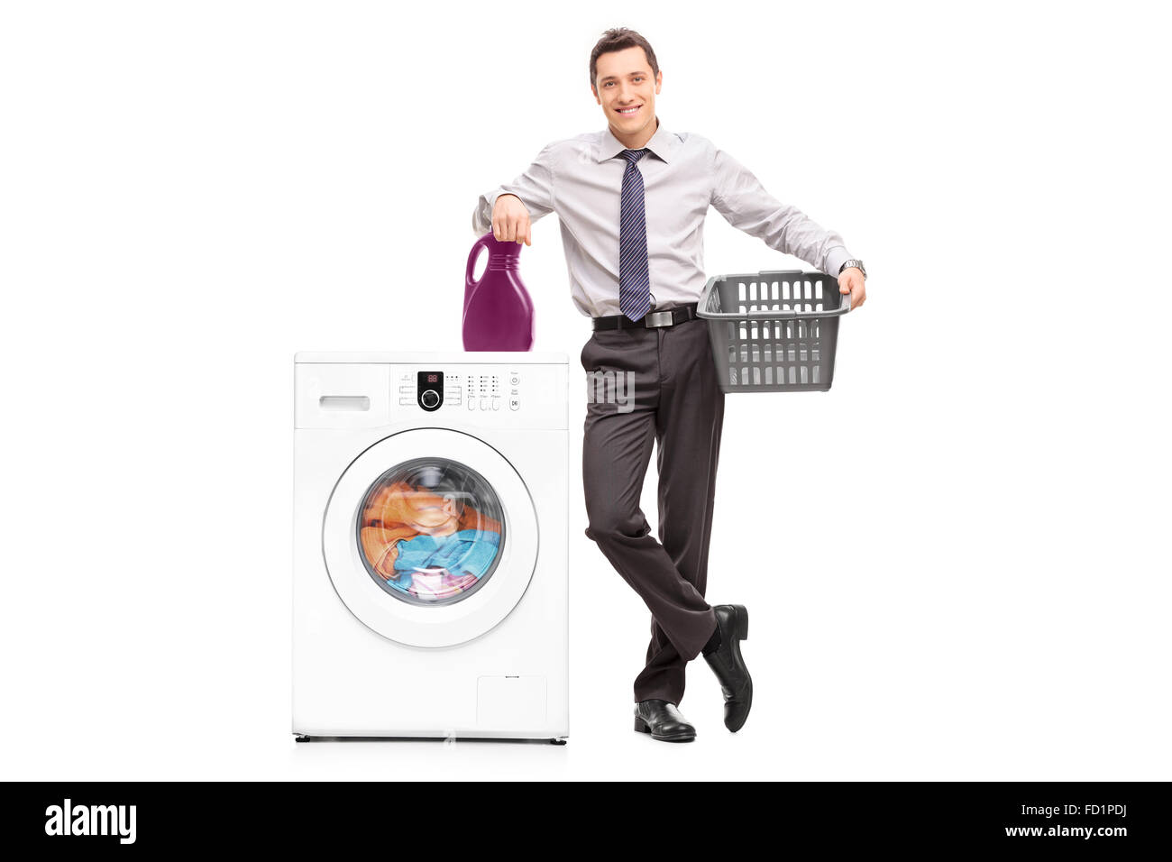 Full length portrait of a young cheerful businessman standing next to a washing machine isolated on white background Stock Photo
