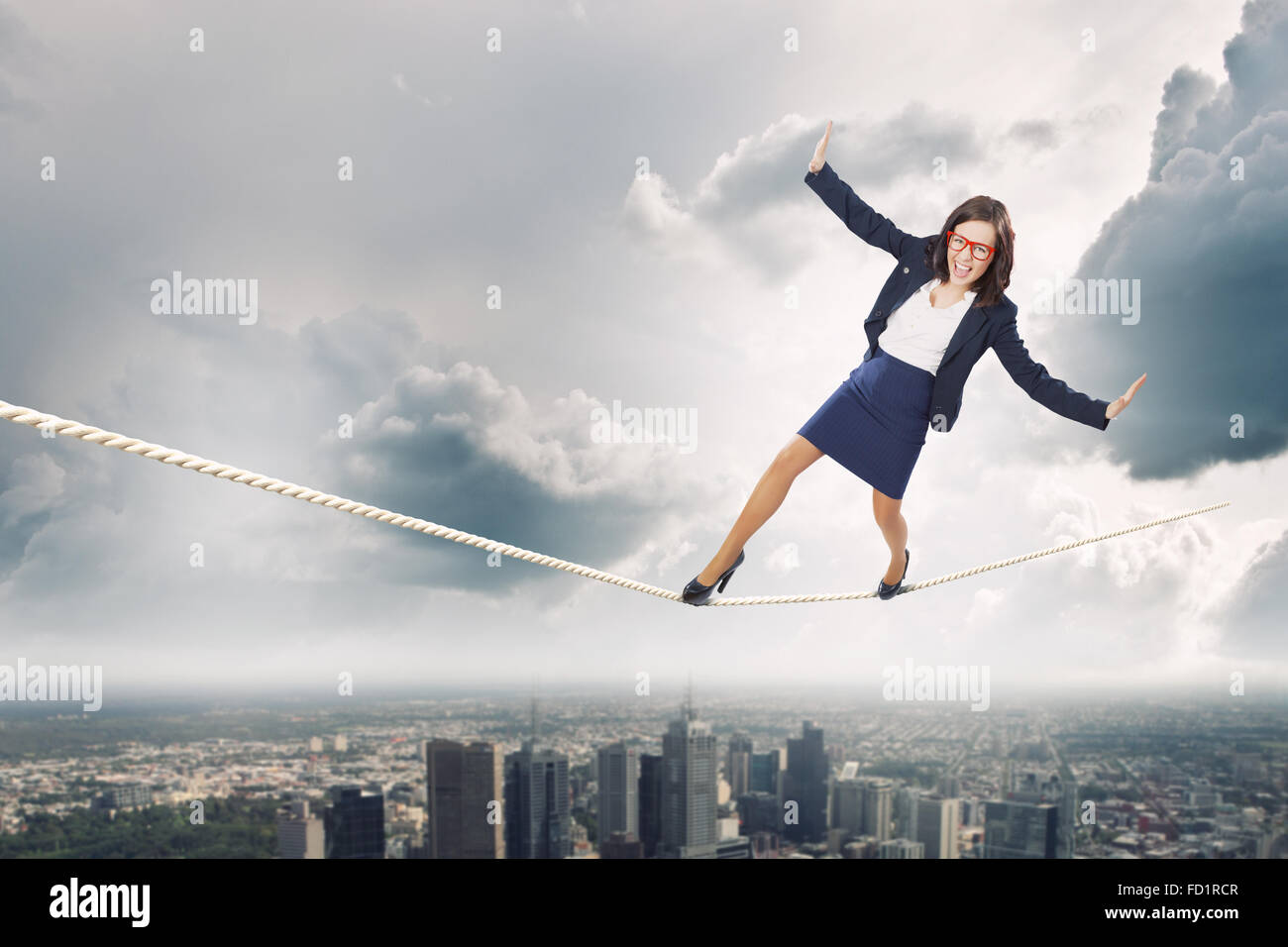Young attractive businesswoman balancing on rope high in sky Stock ...