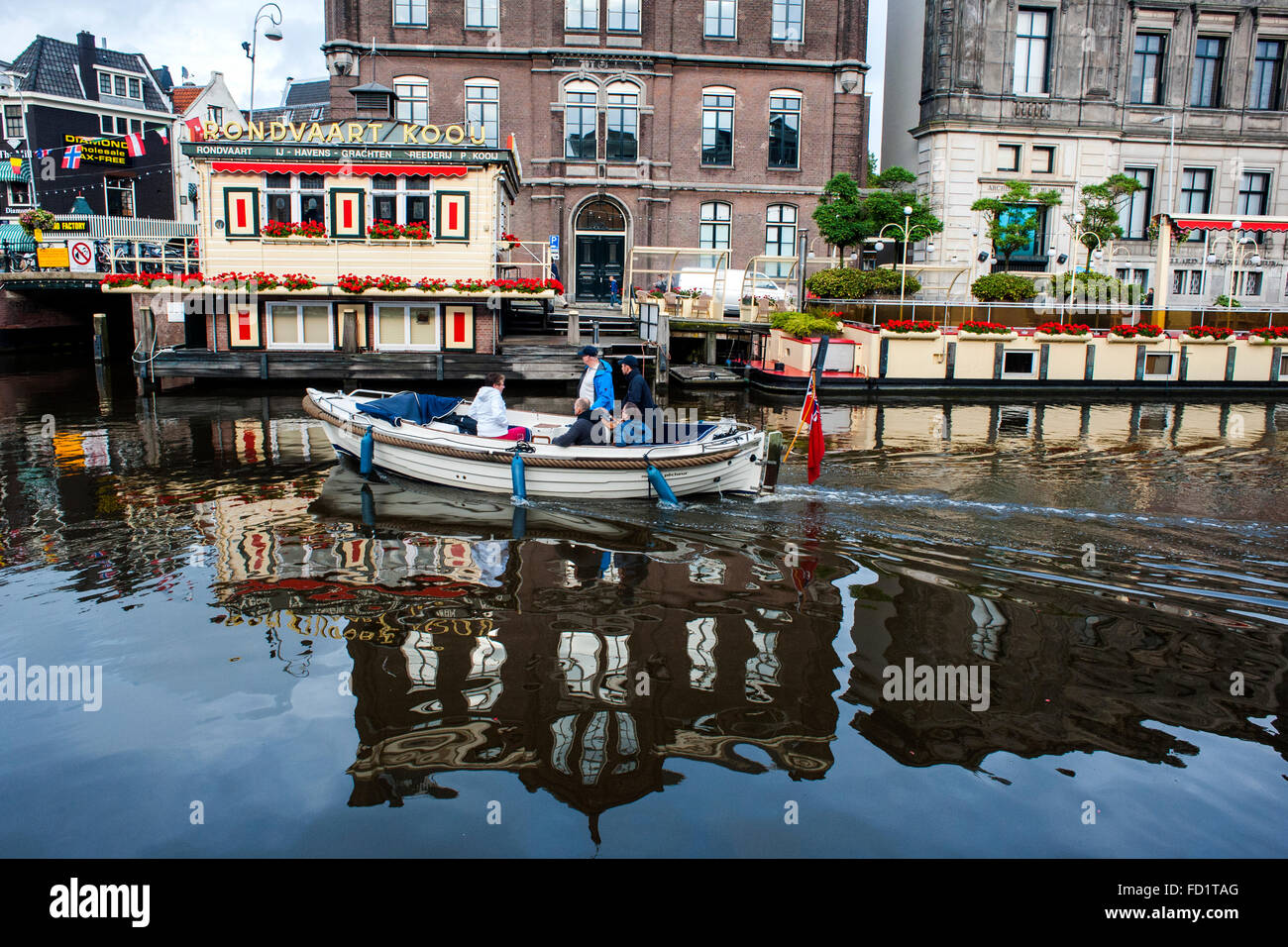 A ship passes through one of the many canals running through the city of Amsterdam Stock Photo