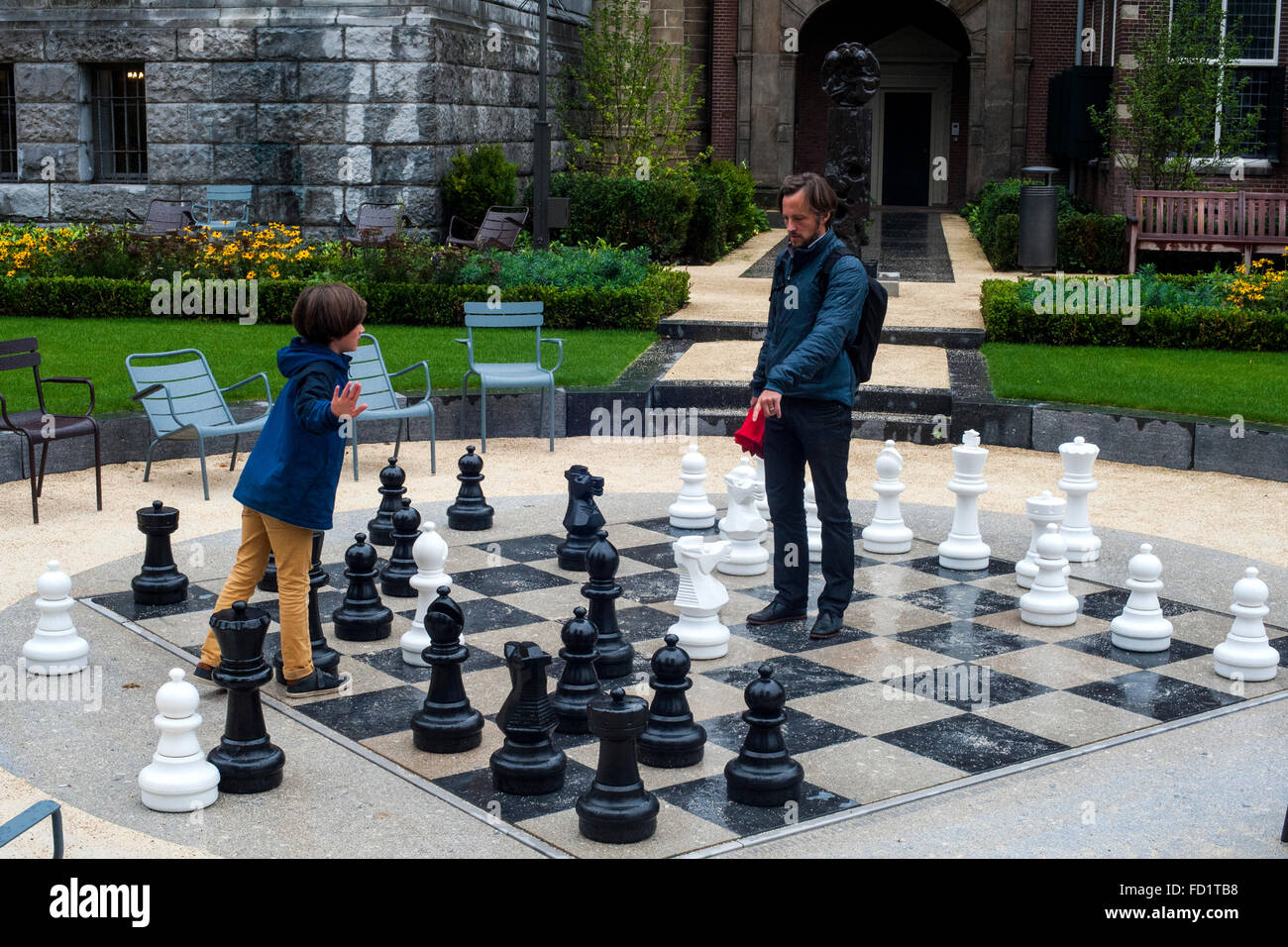 A father playing with his son a giant chess in the Dutch city of Amsterdam Stock Photo