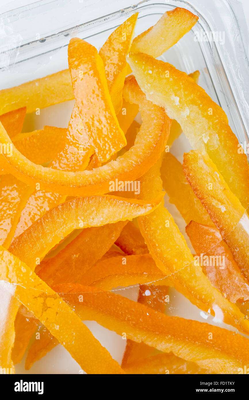 Candied orange peel, cut into sticks, in a plastic box Stock Photo