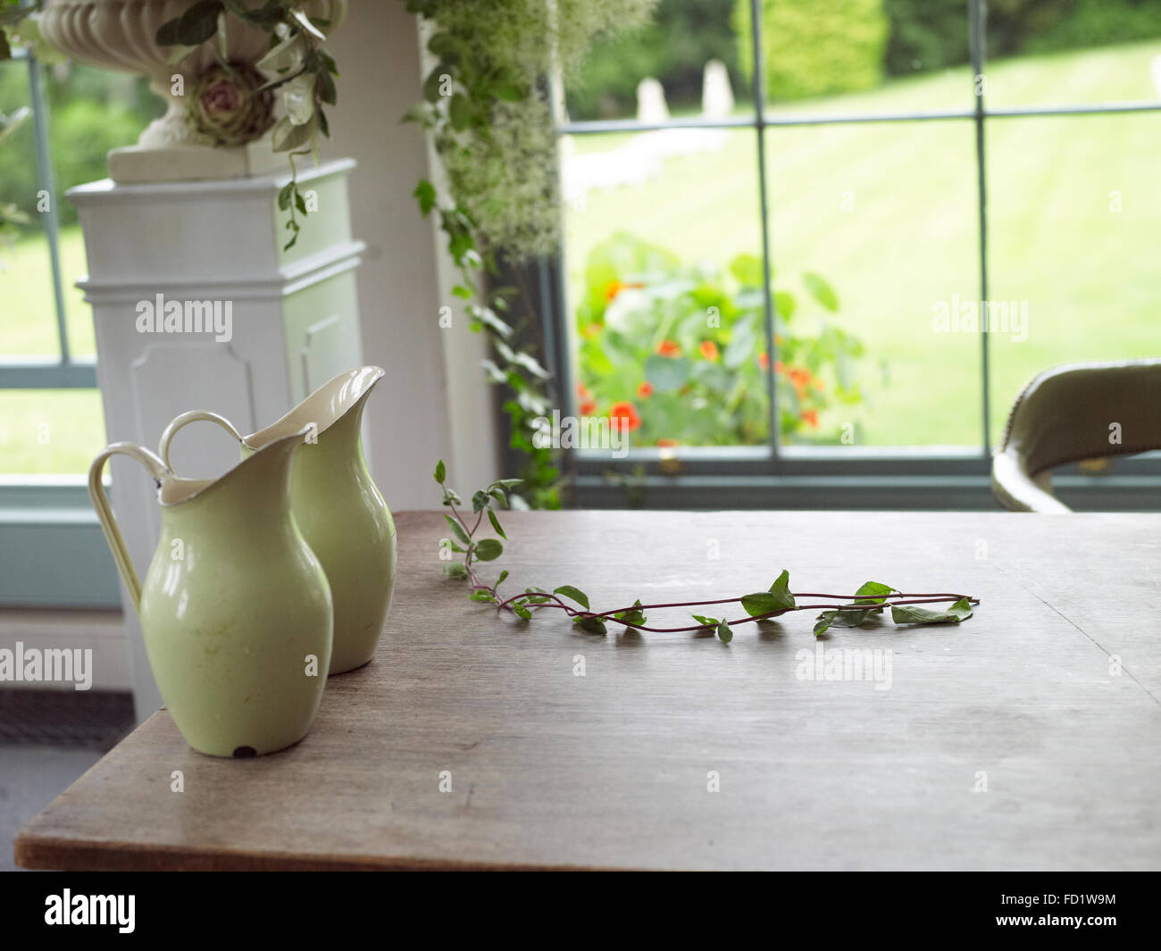 Country scene of flower jugs on a  country table Stock Photo