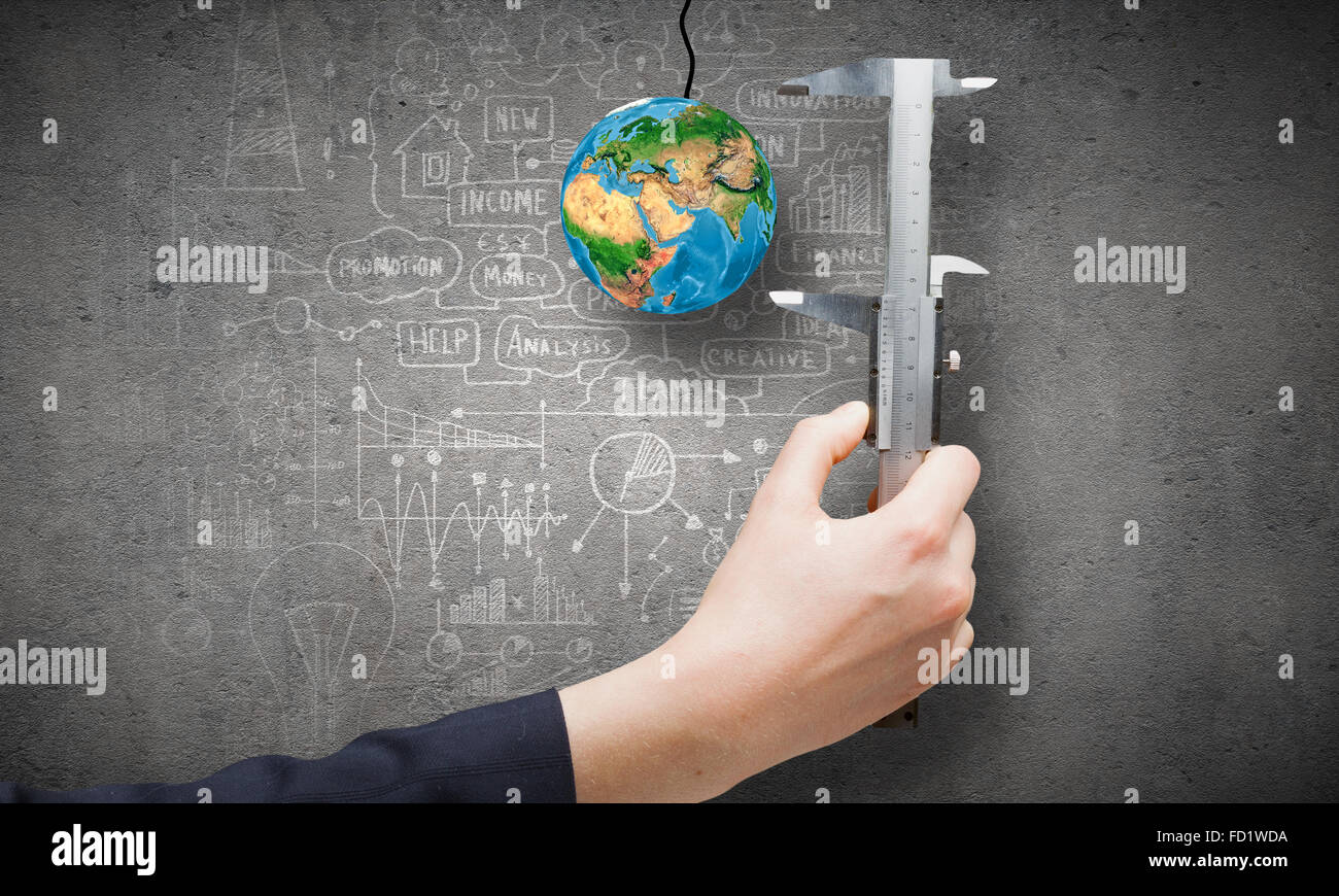 Close up of business person hand measuring Earth planet. Elements of this image are furnished by NASA Stock Photo