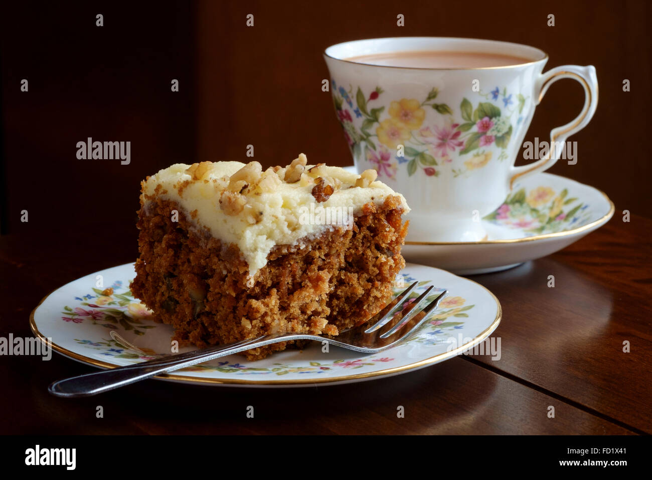 Tea cup and saucer with slice of carrot cake on matching china plate Stock Photo