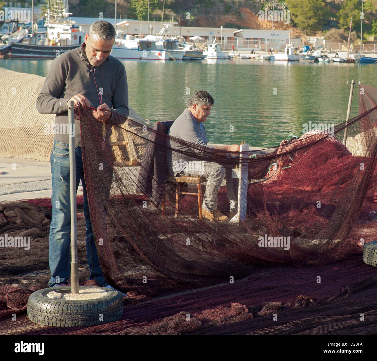 Spanish fishermen repairing their nets. Stock Photo