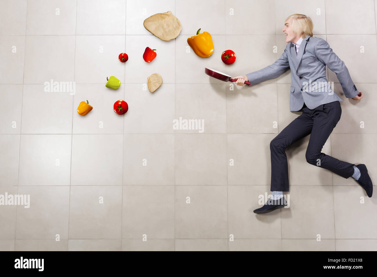 Young funny businessman running with pan in hand Stock Photo
