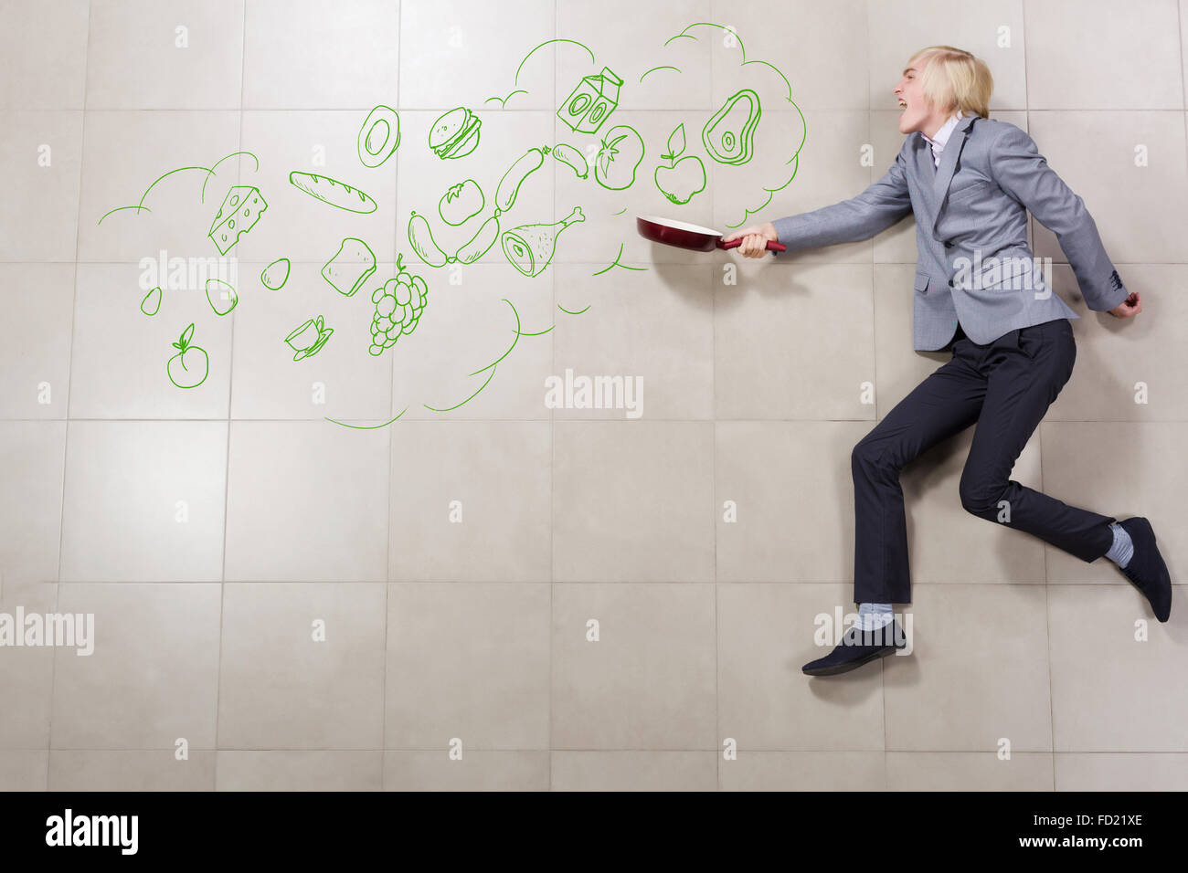 Young funny businessman running with pan in hand Stock Photo