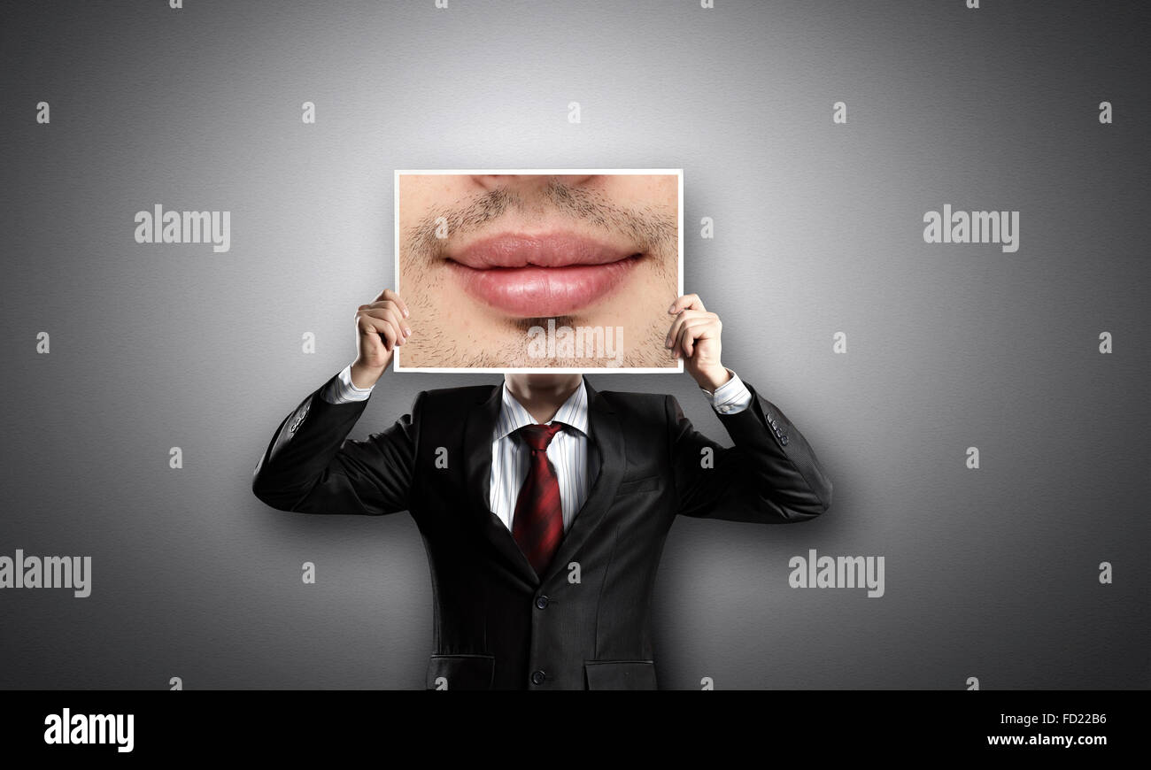 Businessman hiding head behind photo with huge mouth Stock Photo - Alamy