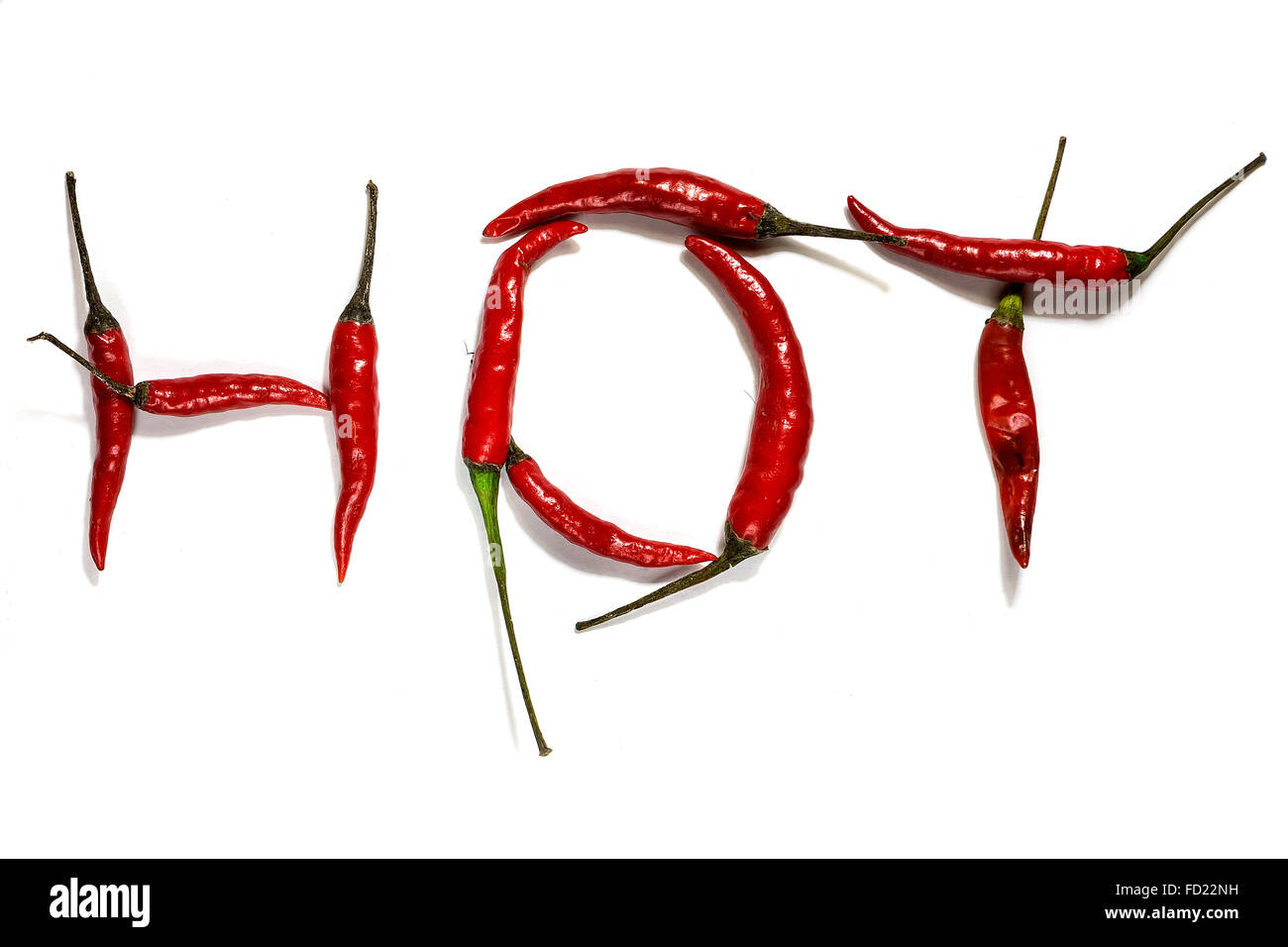 A group of red birds eye chillies on a white background spelling the word hot Stock Photo