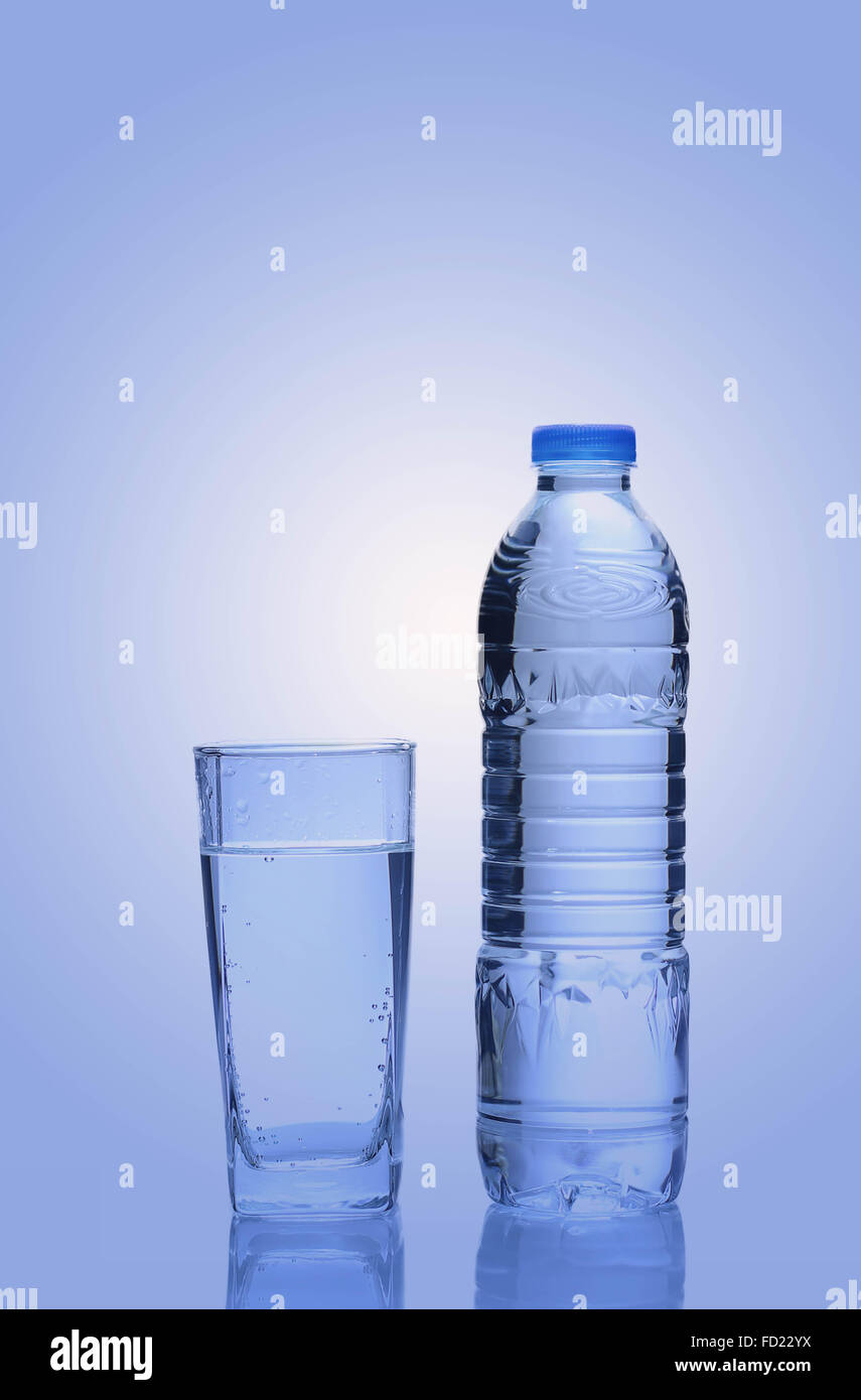 Water in plastic bottle with glass on blue background Stock Photo