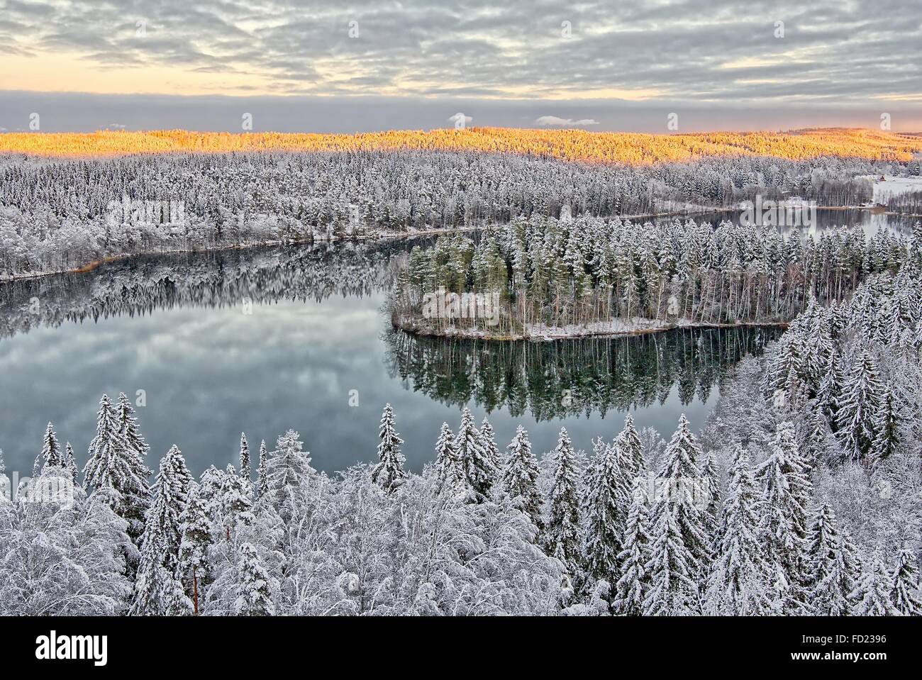 Aerial view of snowy lake and forest at Aulanko nature park in Finland. Late afternoon Sun shining in frozen landscape. HDR imag Stock Photo