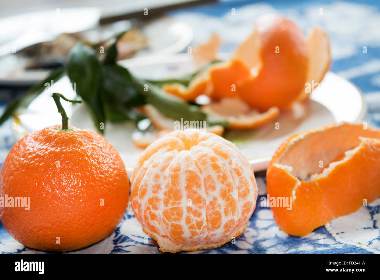 Two ripe clementines one peeled and one whole Stock Photo Alamy