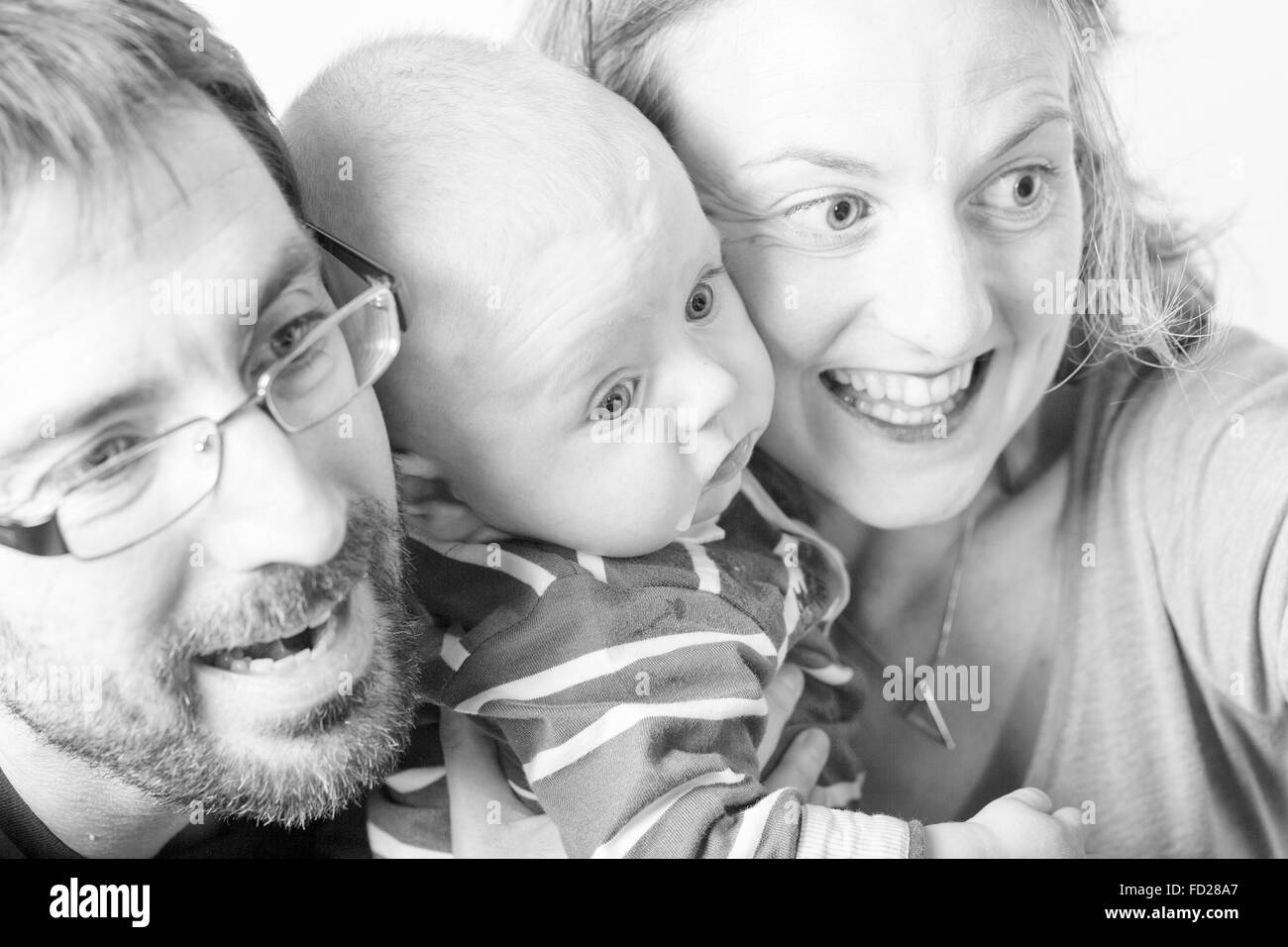 Happy and smiling portrait of Young Parents With Their Baby boy 4 month old Concept happy family Stock Photo
