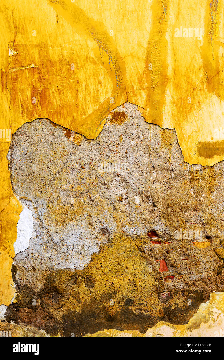 Vintage old damaged wall with cracks, scratches, painted with yellow paint. Textured background for your concept or project. Stock Photo