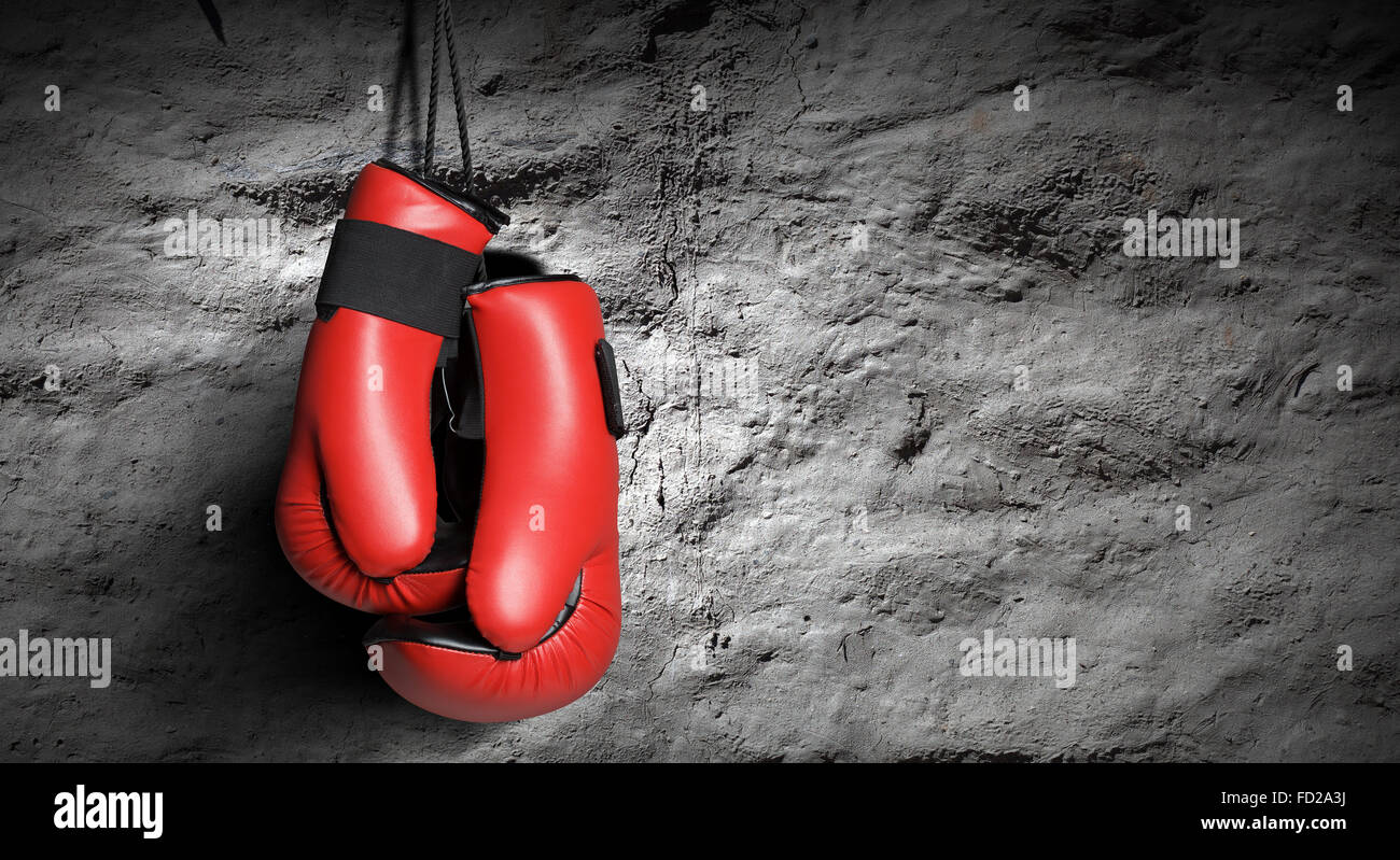 Pair of red boxing gloves hanging on wall Stock Photo