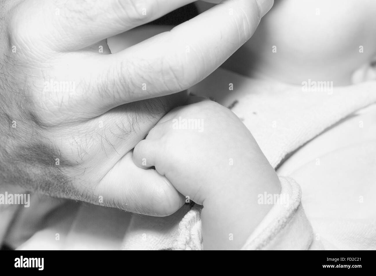 Father mother and baby holding hands family happiness balck and white Stock Photo