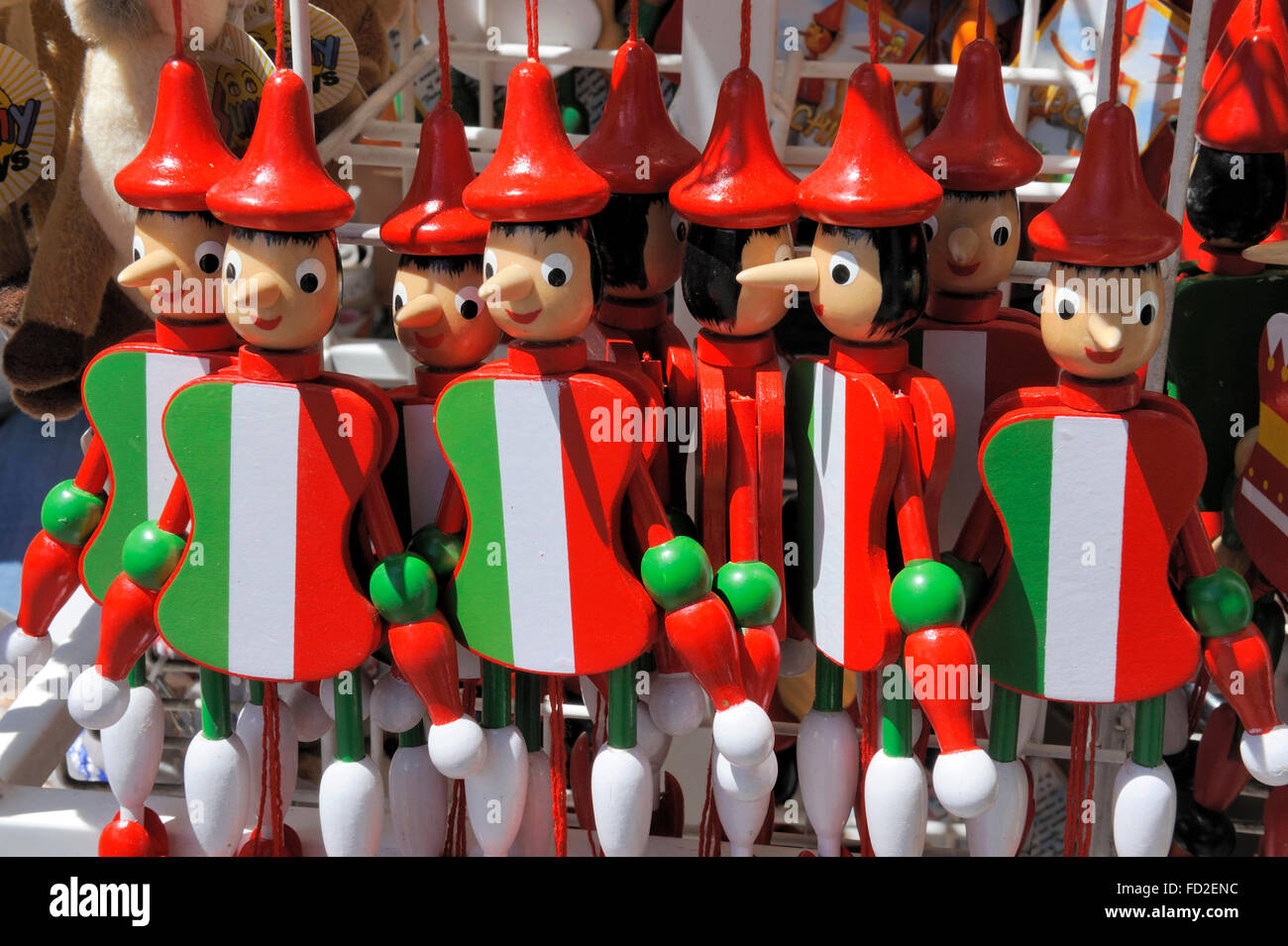 Pinocchio puppets with the Italian flag painted at their body in an Italian souvenirs shop Stock Photo