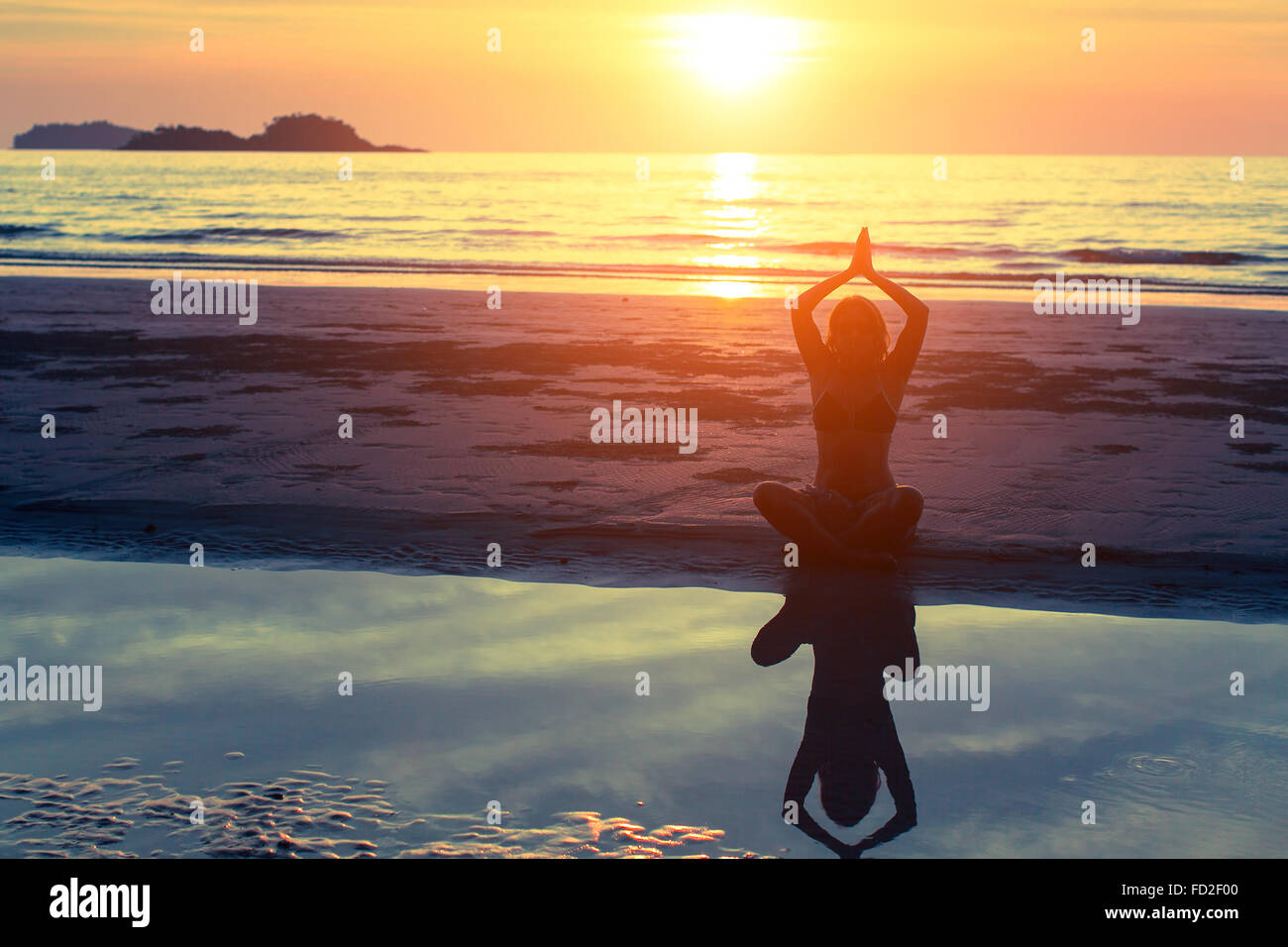 Woman silhouette practicing yoga on the beach at amazing sunset Stock ...