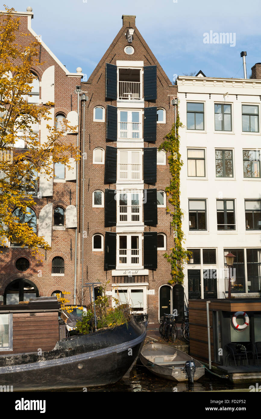 A tall thin Dutch townhouse with traditional wood / wooden shutters on