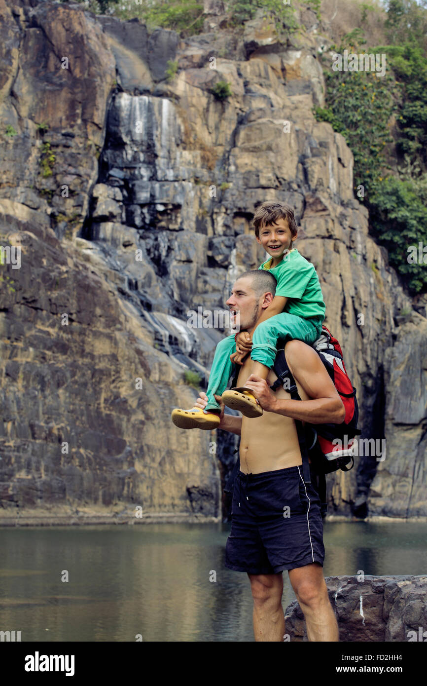 father and son making a trip to waterfall together, happy family on ...