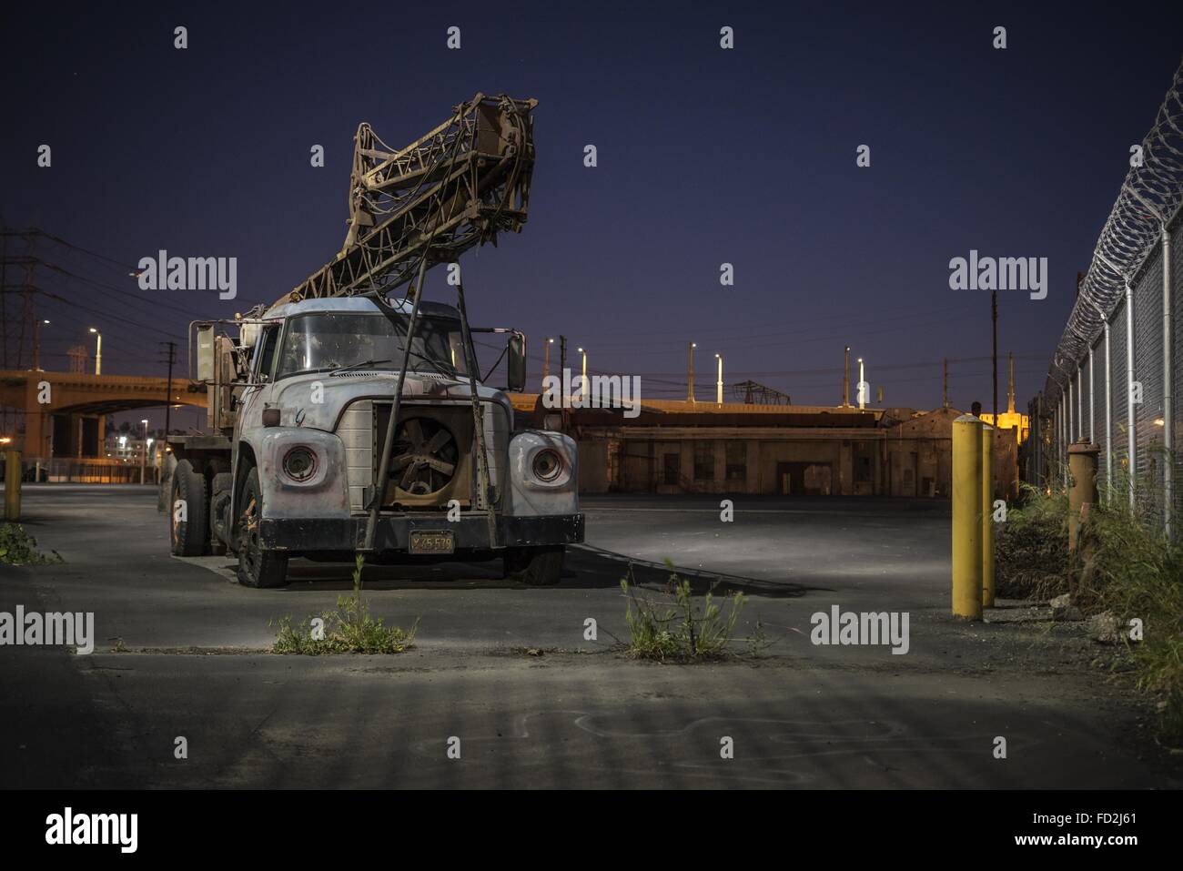 Los Angeles, California, USA. 14th Feb, 2015. An ancient drill-rig sits in the sign-glow of Lucky Brand headquarters, in the Arts District, downtown LA. The 6th Street Bride stands in the background. © Fred Hoerr/ZUMA Wire/Alamy Live News Stock Photo
