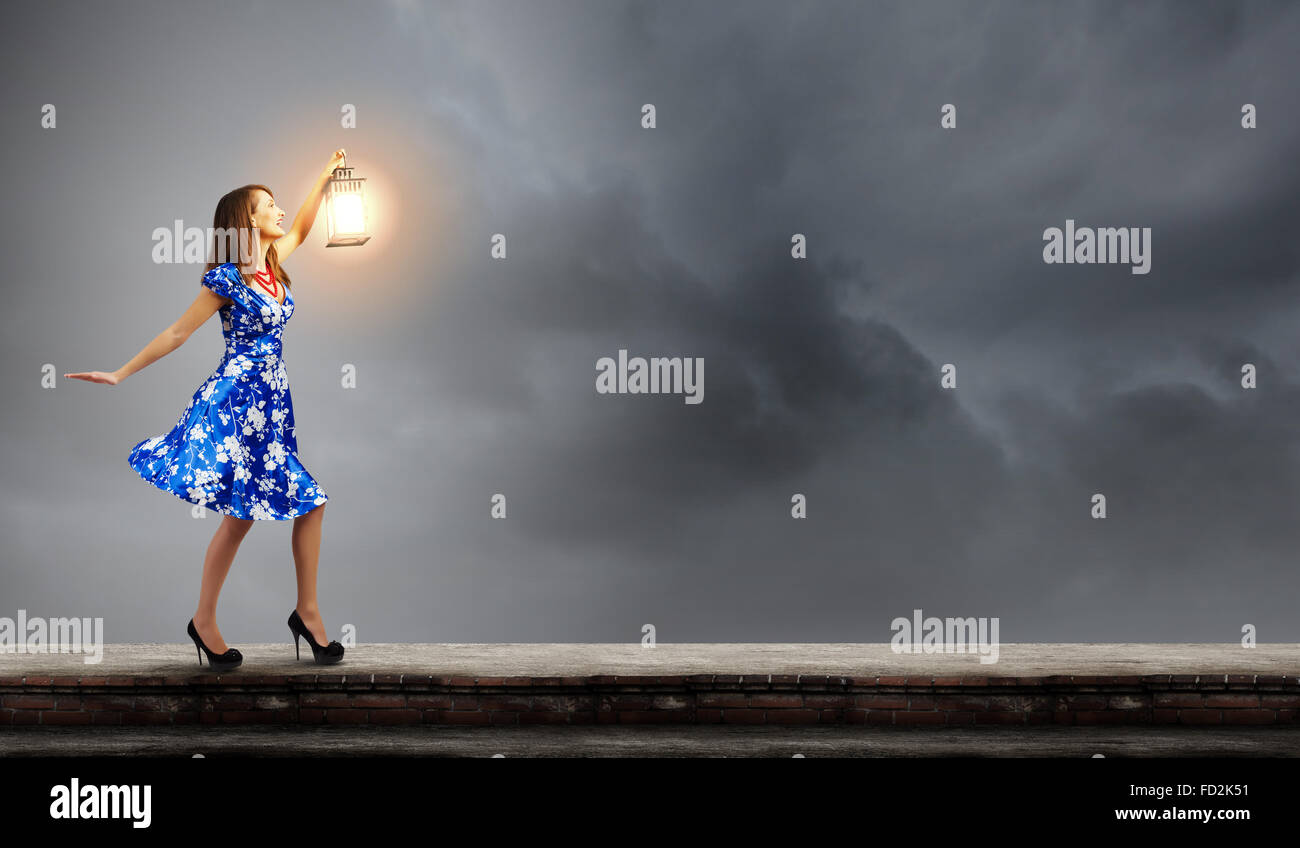 Young woman in blue dress with lantern Stock Photo - Alamy
